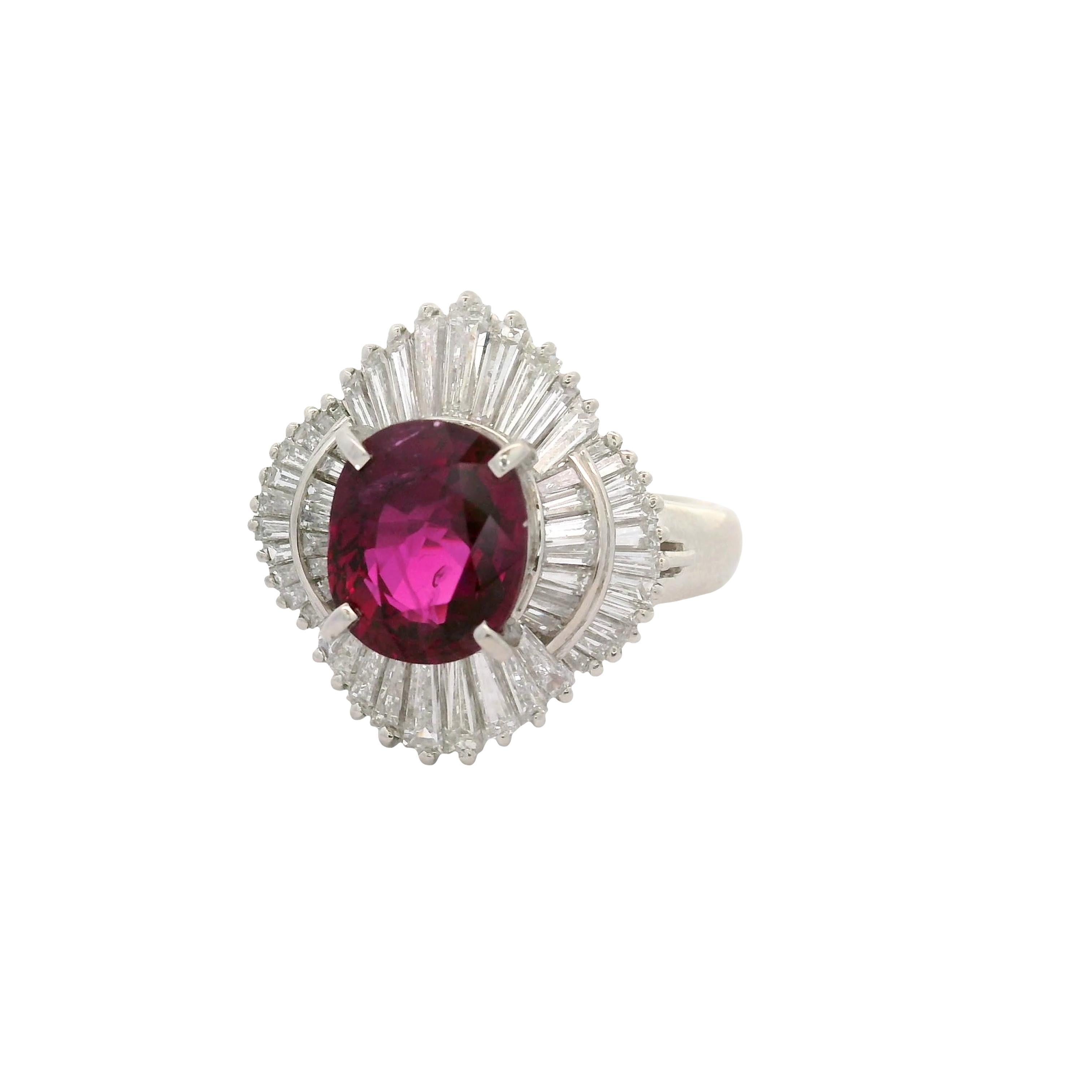 Un rubis captivant pesant 3,11 carats attire l'attention sur cette bague ballerine en platine. Il présente un élégant rubis de forme ovale d'une riche teinte rouge intense et un cristal propre et vibrant. Autour du rubis, des diamants taille