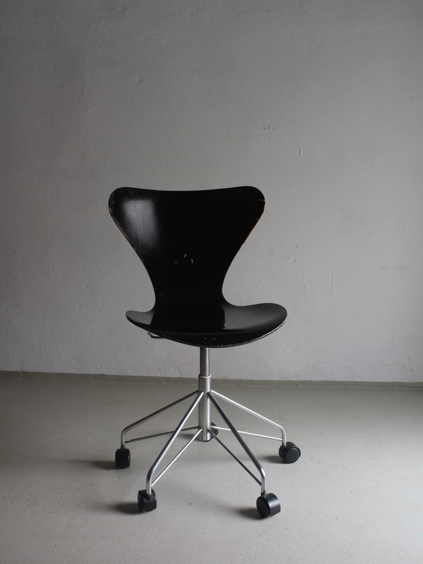 Vintage black swivel desk chair with adjustable seat, model 3117 designed by Arne Jacobsen for Fritz Hansen in the 1950s. Some chairs have stickers confirming the production period. 3 chairs are available. 
Dimensions - H(max/min) 85.5/51 cm,