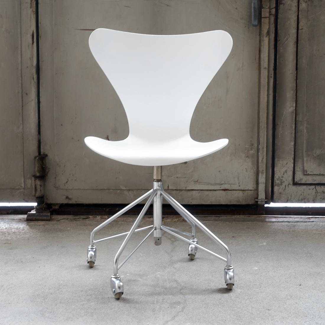 This chair was designed by Arne Jacobsen manufactured by Fritz Hansen in the 1970s. The seat and back are formed from a white painted laminate and shows the typical design of this model. All parts such as the castors, rubber wheels and rubber seat