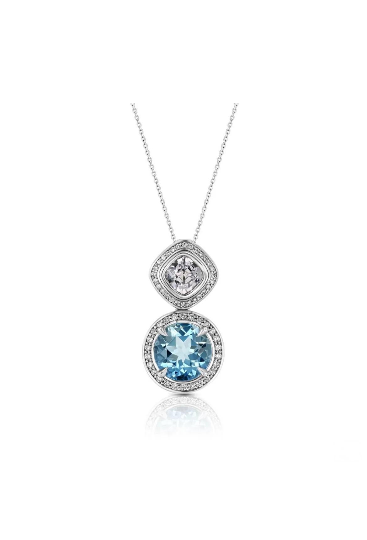 A beauteous 1.22ct cushion-cut lavender spinel shines with a 3.11ct round Aquamarine, encircled with numerous white diamonds totaling 0.31cts in an 18K white gold pendant. 