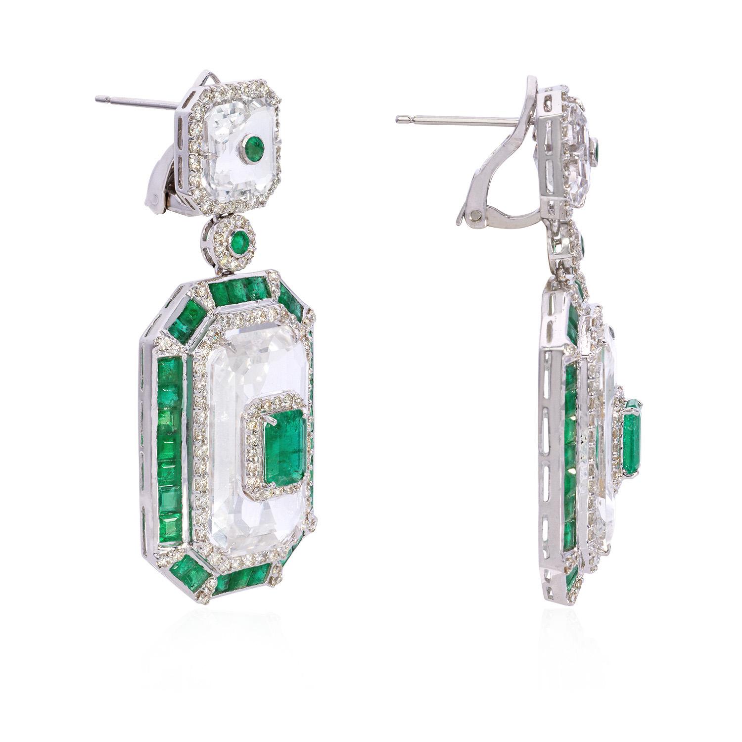 These emerald earrings boast a lush green hue that will add a touch of glamour to your look. The emeralds are complemented perfectly by round diamonds, which are expertly cut and set for maximum sparkle. The crystals add an extra shine to the