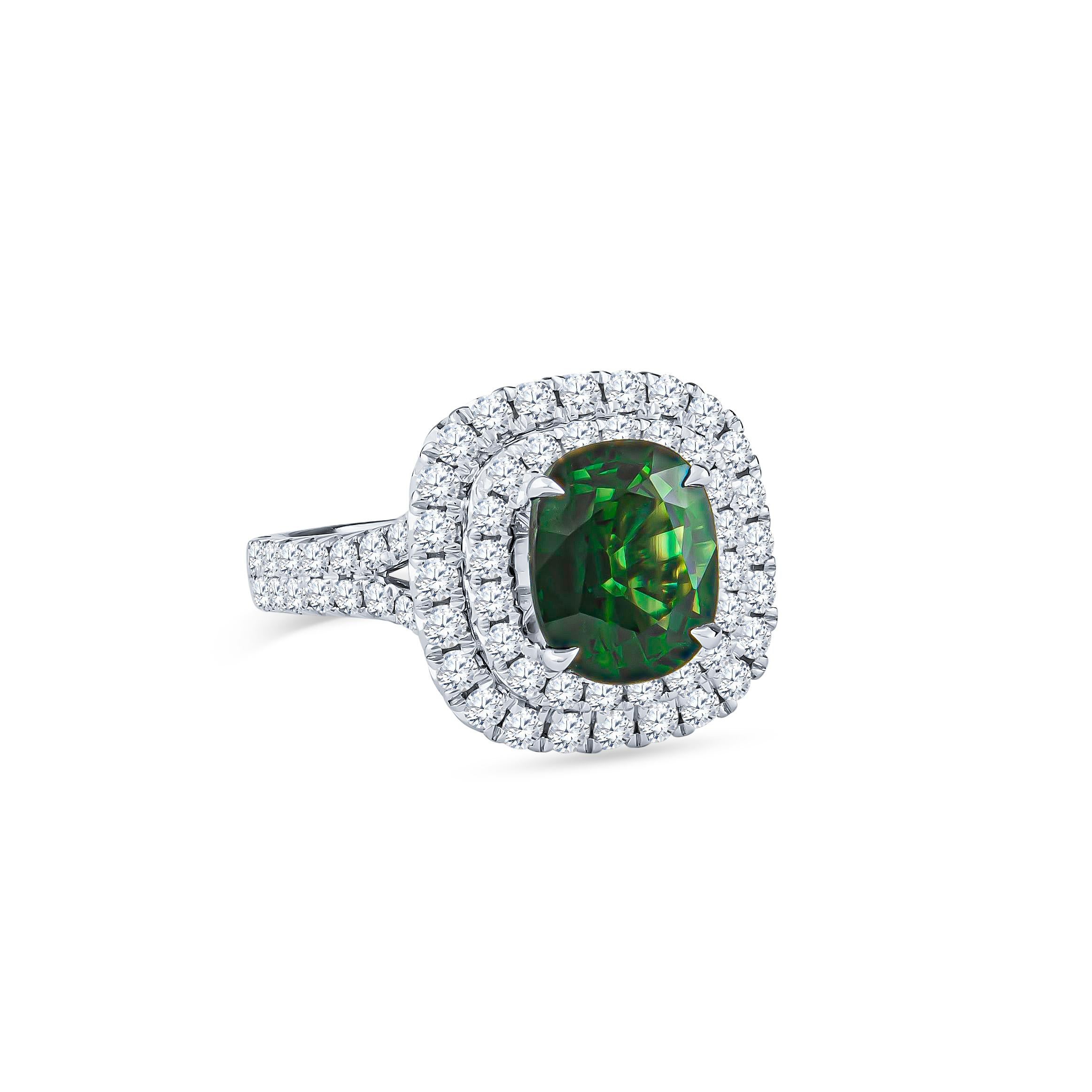 Gorgeous 18k white gold ring spotlighting a GIA graded cushion cut green sapphire weighing 3.12 carats surrounded by 1.17 carats total fine round brilliant cut diamonds set in double halo form (F-G color VS2-SI1 clarity). Ring was crafted in a size