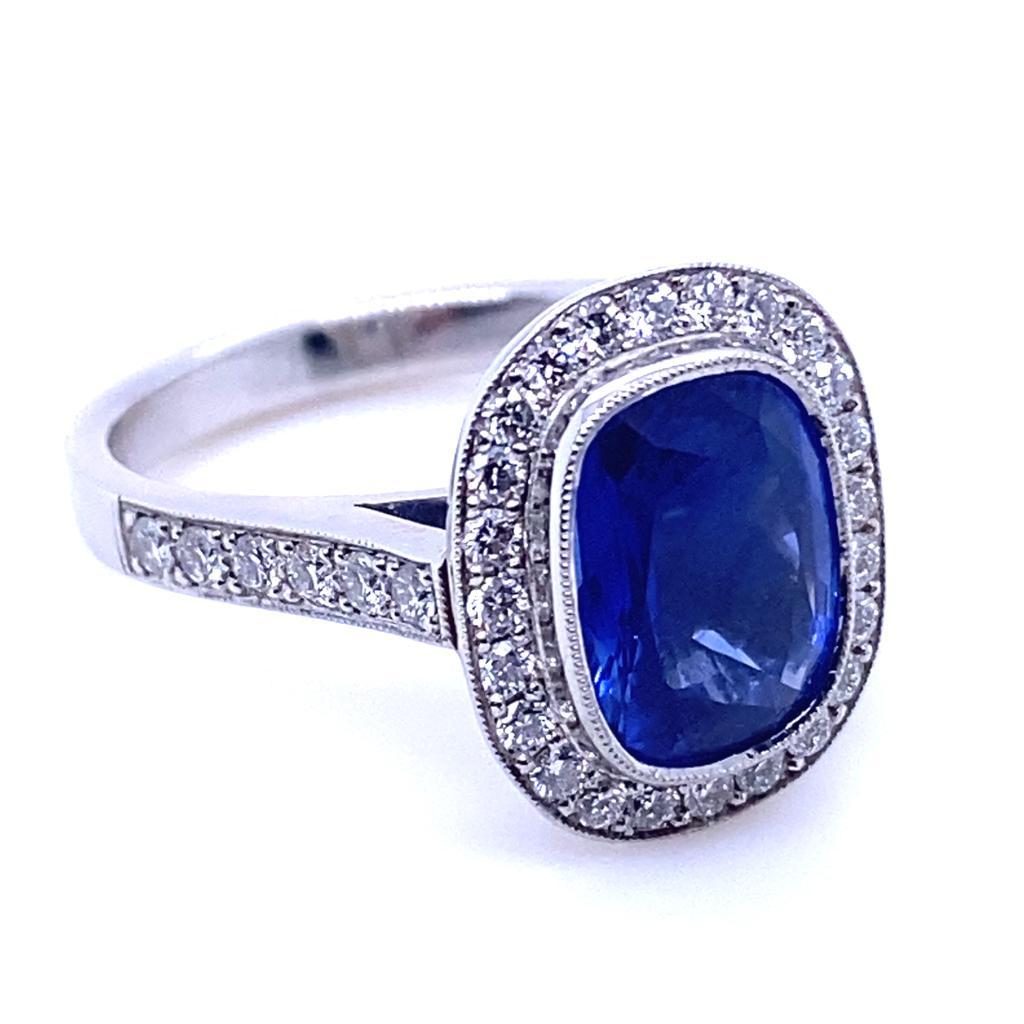 A 3.12 carat sapphire and diamond platinum cluster engagement ring.

This exceptional cluster ring is set with an outstanding royal blue sapphire cushion cut centre and round brilliant cut diamond surrounds leading to further half diamond set