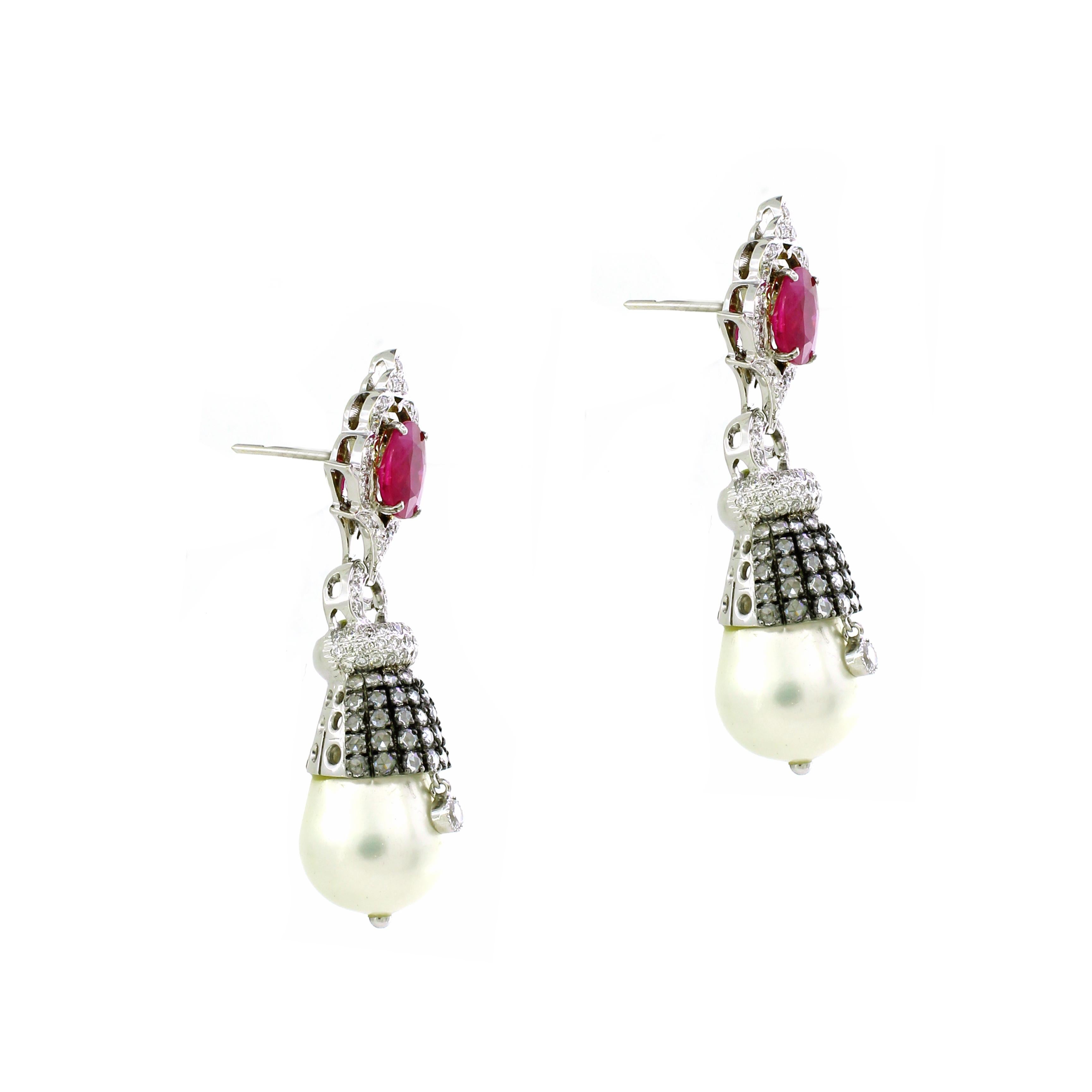 Indulge in the timeless elegance of our Pearl Drop Earrings, a stunning masterpiece crafted in luxurious 18K white gold, weighing a total of 20.85 grams. At the apex of each earring sits a pair of majestic rubies, totaling 2.71 carats, exuding a