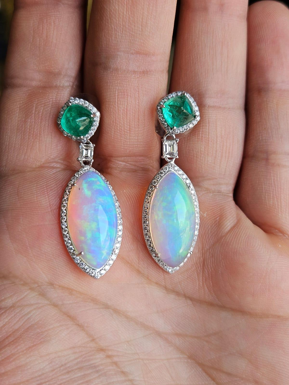 A very gorgeous and beautiful, Emerald & Opal Dangle Earrings set in 18K White Gold & Diamonds. The weight of the Emerald Sugarloafs is 3.12 carats. The Emerald sugarloafs are completely natural, without any treatment and are of Colombian origin.