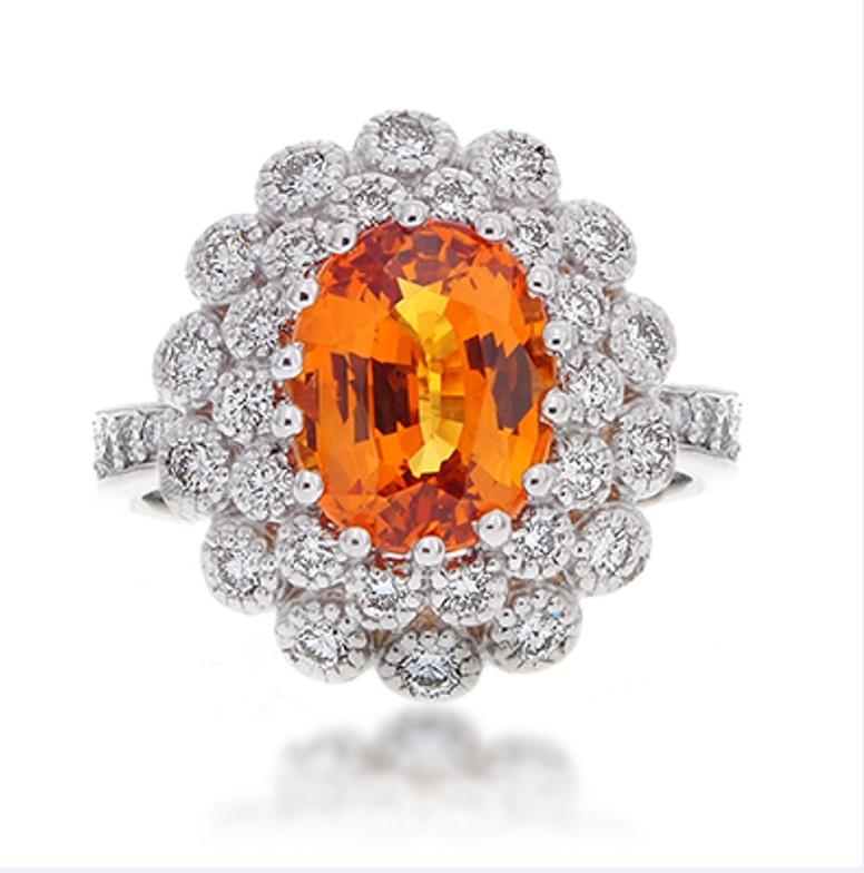 Classic Style 3.13 Carat Heated Oval Cut Natural Orange Sapphire Precious Gemstone mounted in a 14 Karat White Gold with Diamond Halo Ring.
Total Carat Weight on the ring is 3.88.
The large Heated Oval Shaped Orange Sapphire Gemstone has a deep and