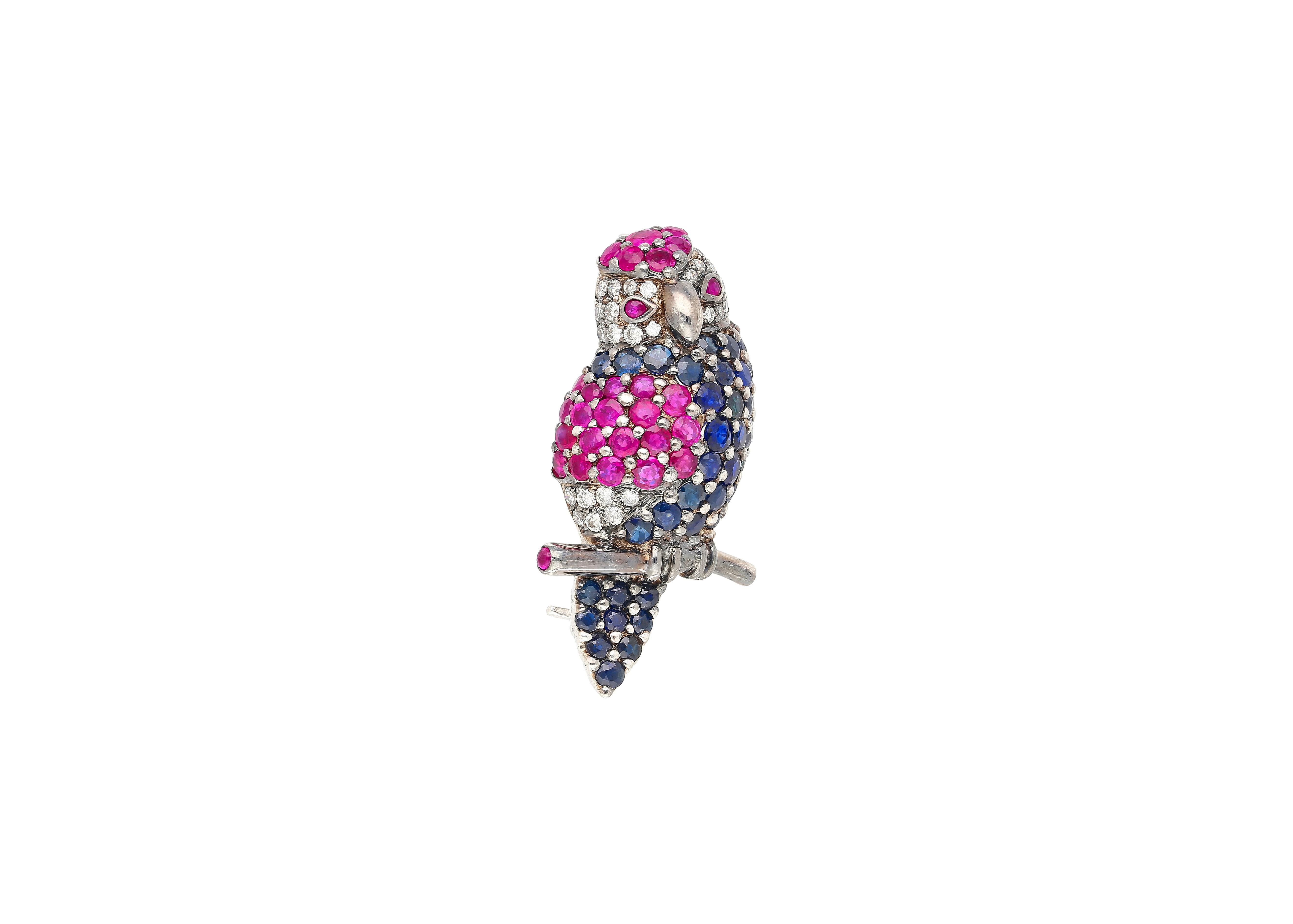 Broche perroquet fantaisiste en or blanc 18 carats, sertie de 3,14 carats de saphirs roses et bleus et de 0,27 carat de diamants blancs. Conçue avec des détails charmants et réalistes, cette pièce ludique ajoute du caractère à toute