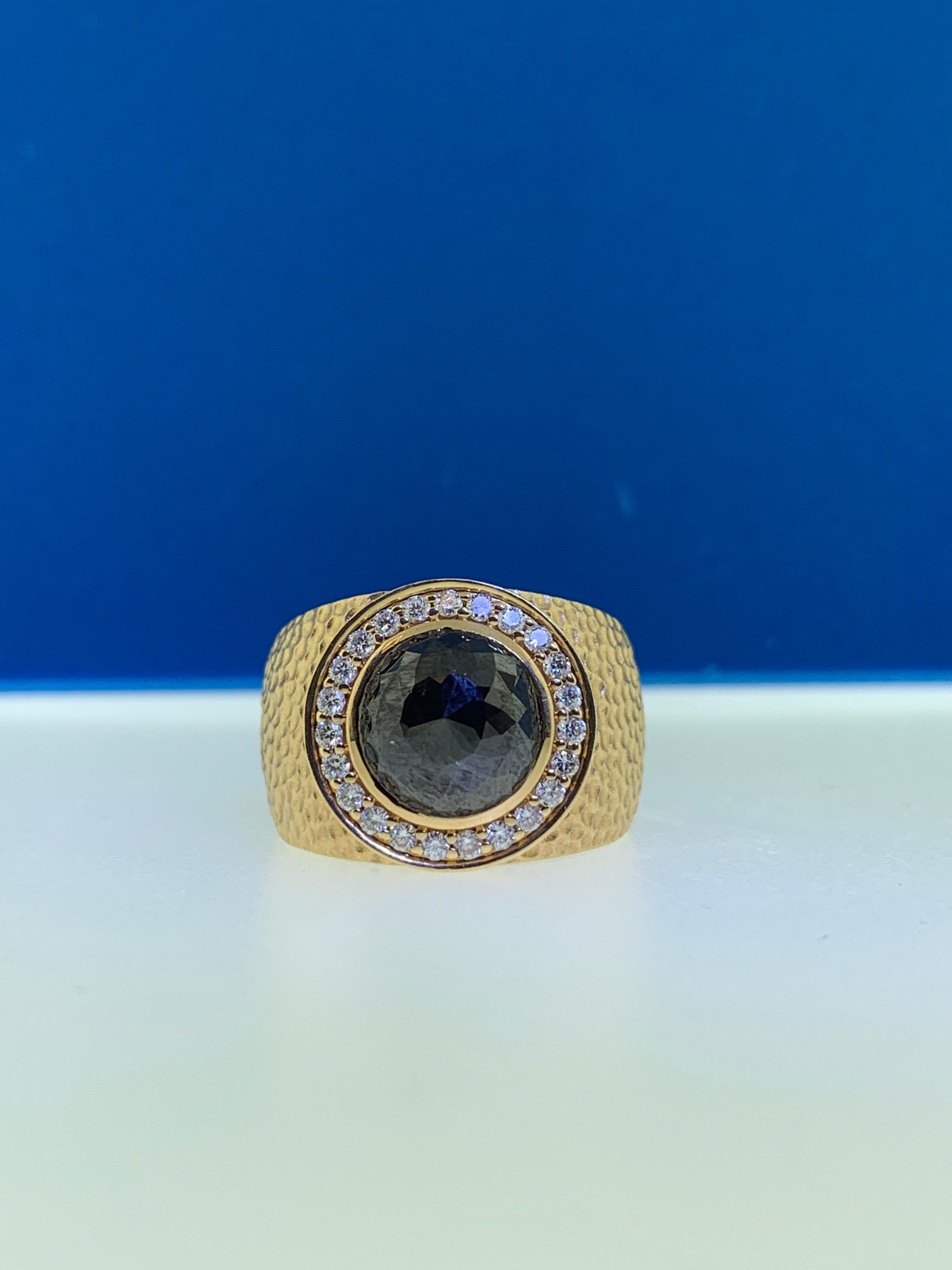 This stunning cocktail ring showcases a beautiful 3.14 carat rose cut black diamond with a white diamond halo set in 18 karat yellow gold. 
Total diamond weight (not including center stone) = 029 carats. Ring size is 6 1/2.
