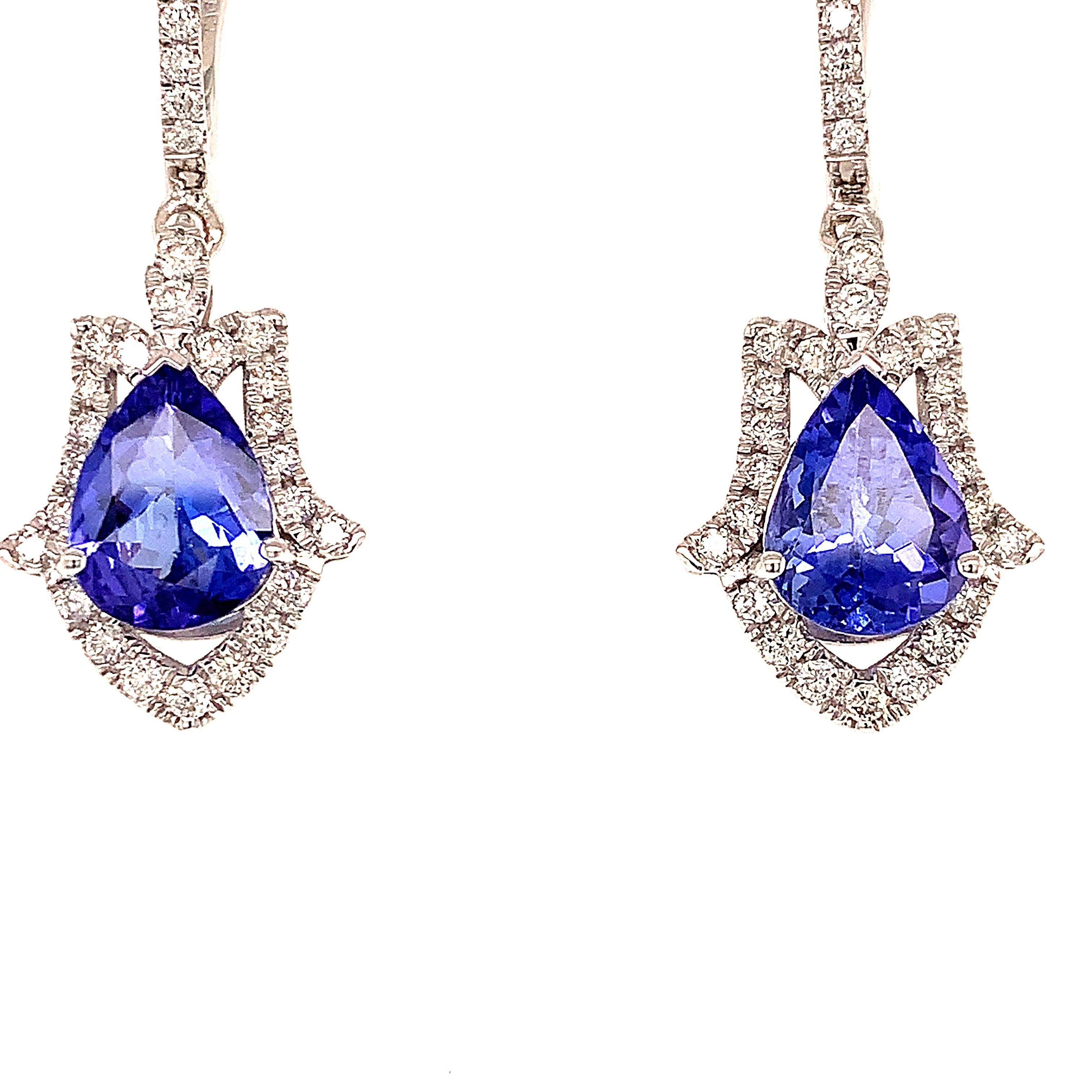 Elegant tanzanite diamond dangling earrings. High brilliance, pear faceted, violet-blue tone natural 3.14 carats tanzanite set in basket mount with three bead prongs, accented with a round brilliant cut diamond. Handcrafted design set in 14 karats