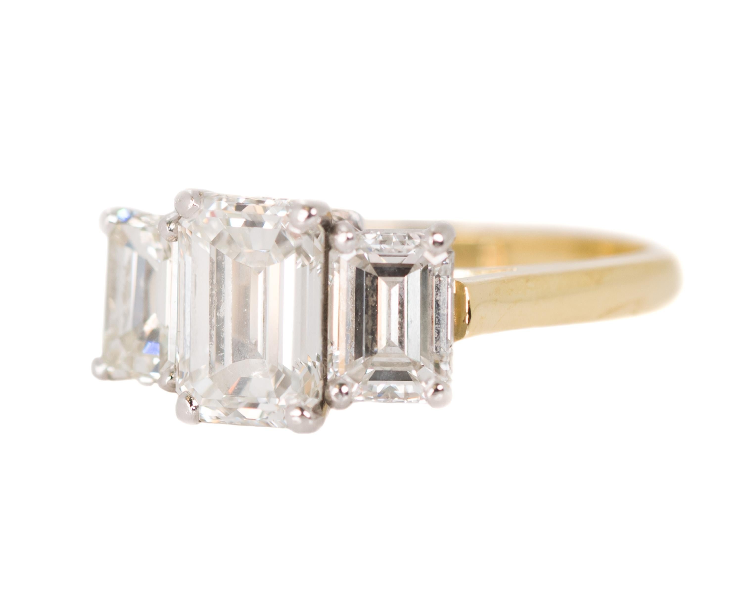 Modern 3.14 Carat Total Diamond, Platinum, 18 Karat Gold Three-Stone Emerald Cut Ring