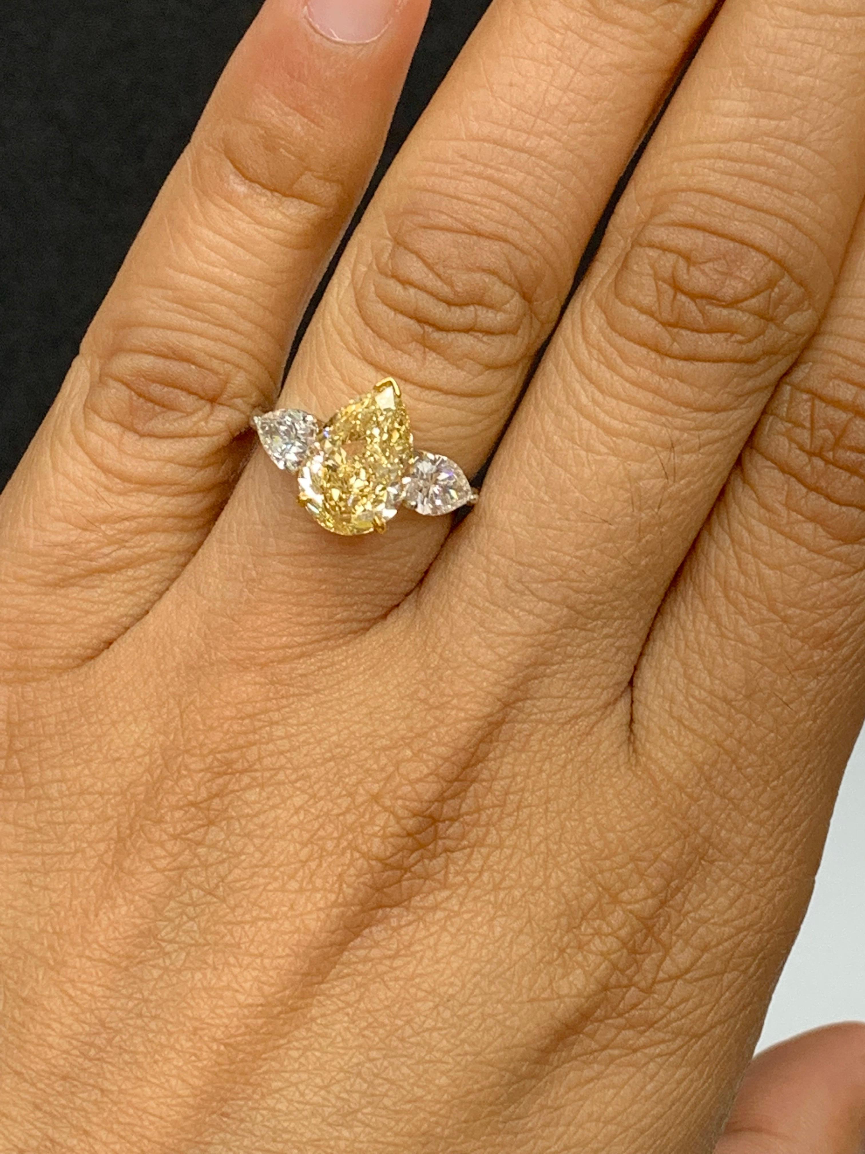 Modern 3.15 Carat Pear Shape Fancy Yellow Diamond 3 Stone Ring in Platinum For Sale
