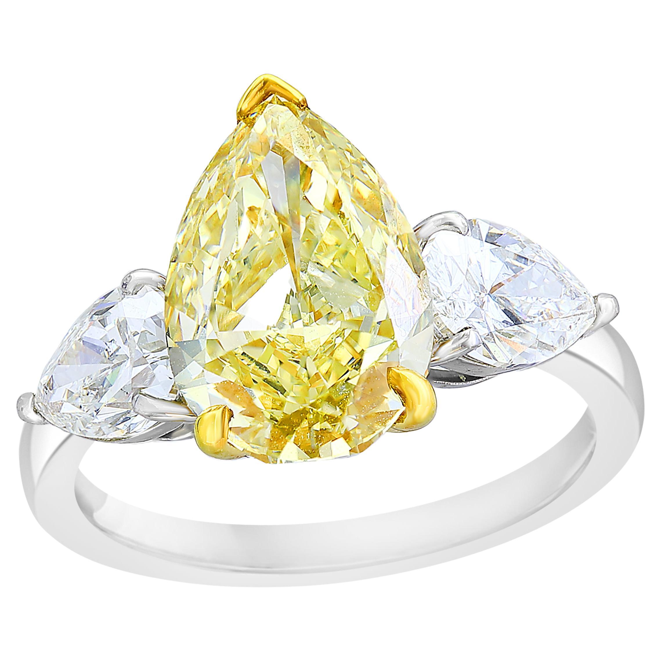 3.15 Carat Pear Shape Fancy Yellow Diamond 3 Stone Ring in Platinum For Sale