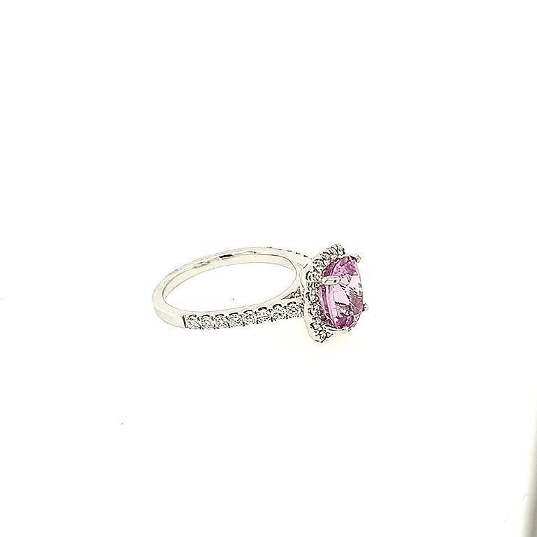 Crafted in 18k white gold featuring (1) cushion cut pink sapphire weighing 3.15ct and surrounded by (34) round diamonds weighing approximately .72ttw with a color of G/H and a clarity of SI1 to SI2. The ring is a size 6.5.