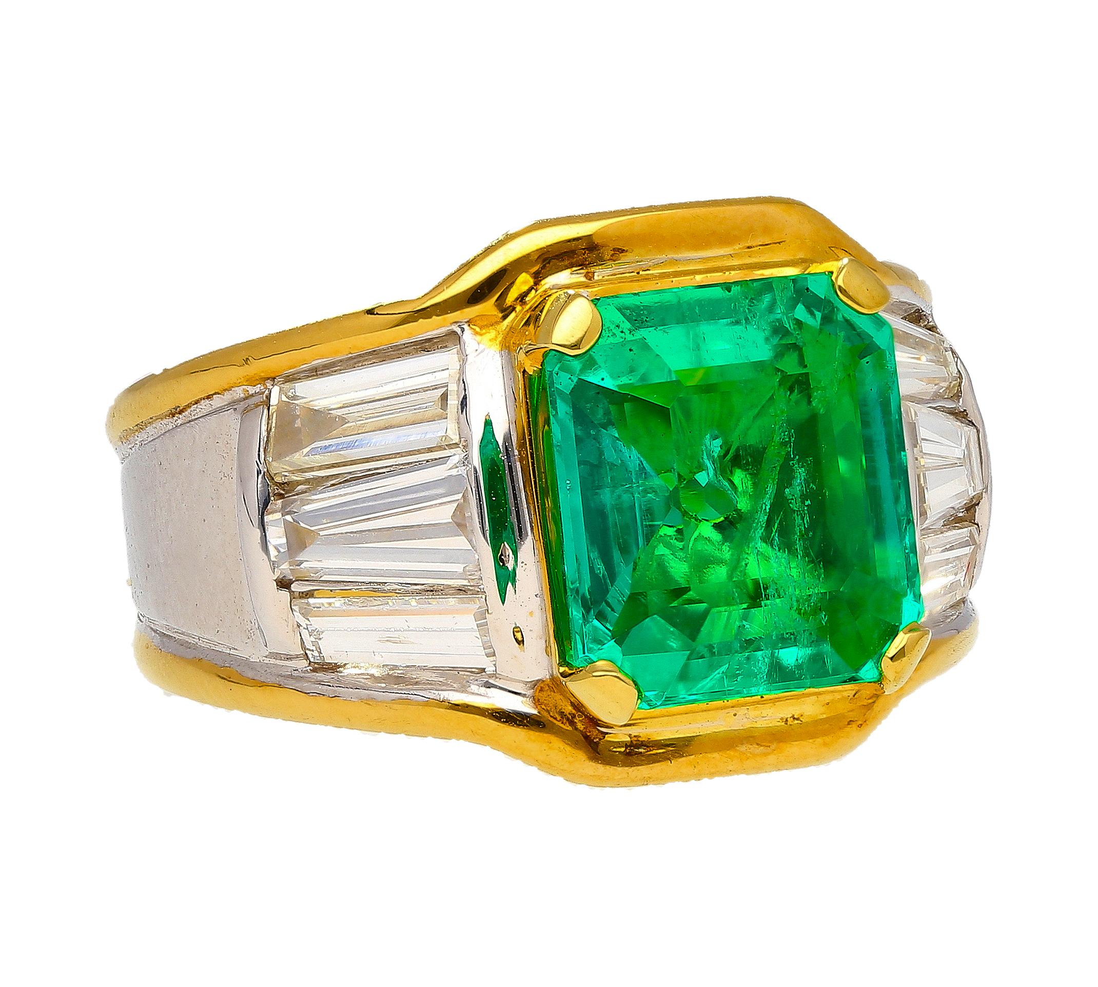 Vintage platinum 900 and 18k yellow gold two-tone multi gemstone ring with a single emerald and multiple diamonds. The center stone is a 3.16 carat vivid green Colombian emerald with insignificant oil treatment. A truly significant feat considering
