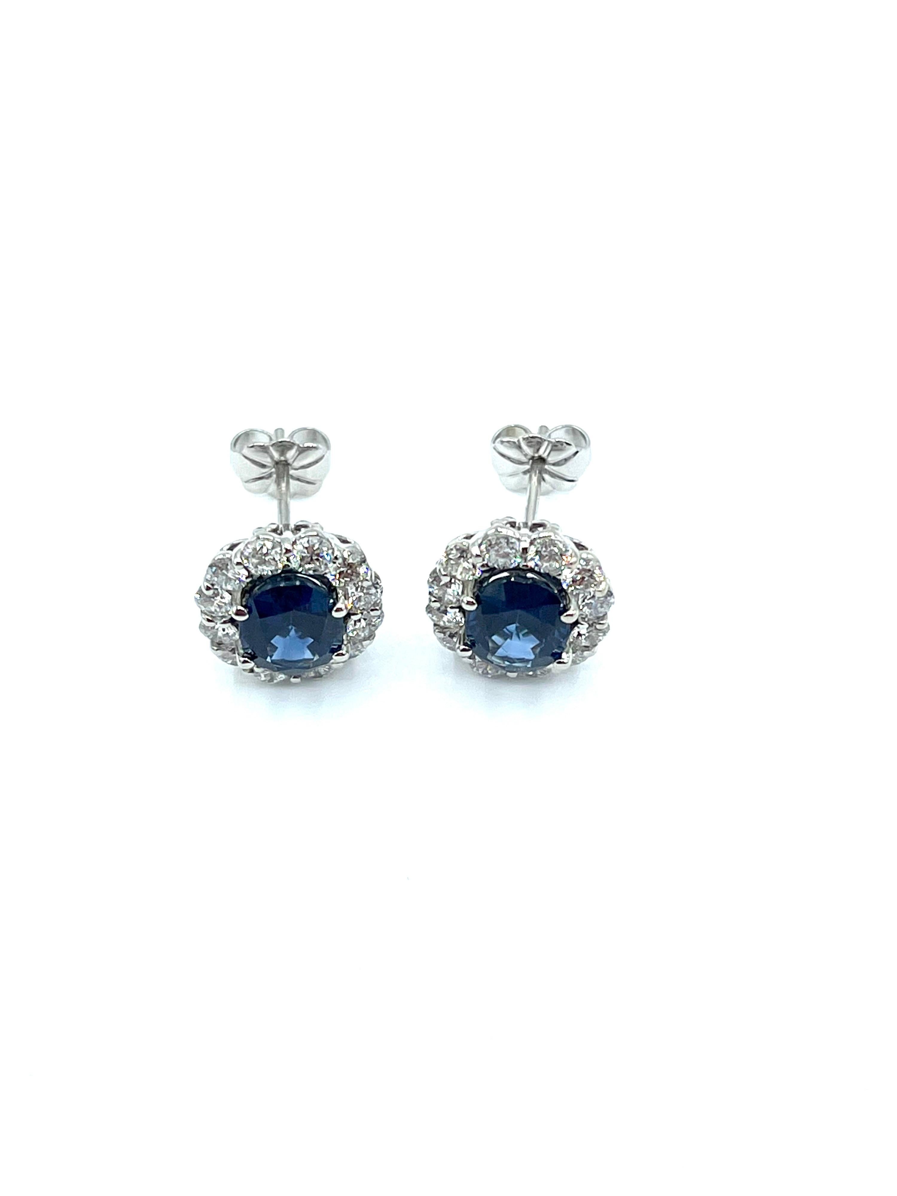 Ein wunderschönes Paar Ohrringe aus blauem Saphir und Diamant!  Die beiden ovalen Saphire sind in vier Zacken gefasst, umgeben von einer einzigen Reihe runder Diamanten im Brillantschliff, auf einem mittig montierten Pfosten.  Die beiden Saphire