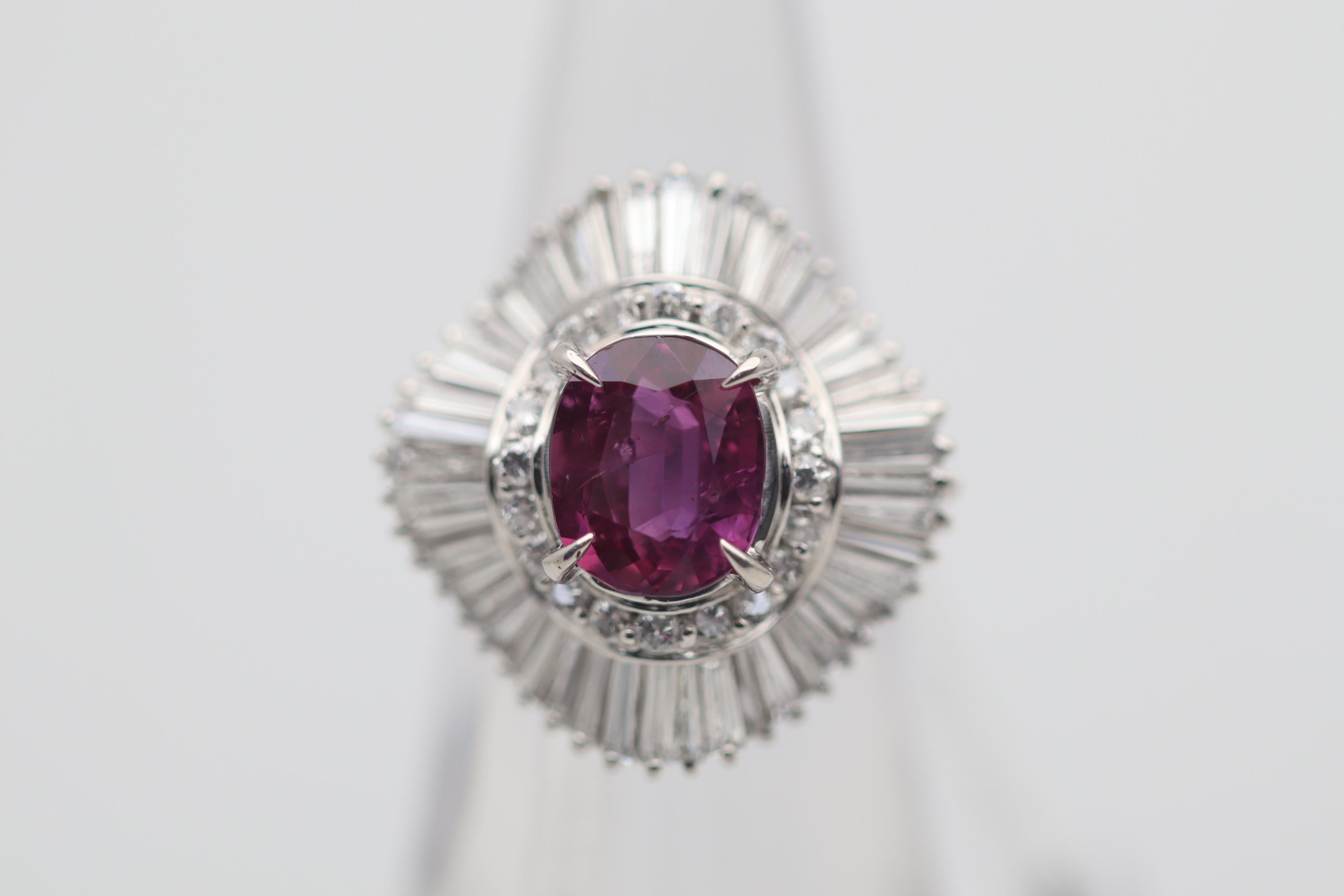 A classic ballerina style ring featuring a large 3.16 carat ruby! It has an oval shape with a bright rich color. It is complemented by 3.08 carats of baguette-cut and round brilliant-cut diamonds spiraling around the ruby. Hand-fabricated in
