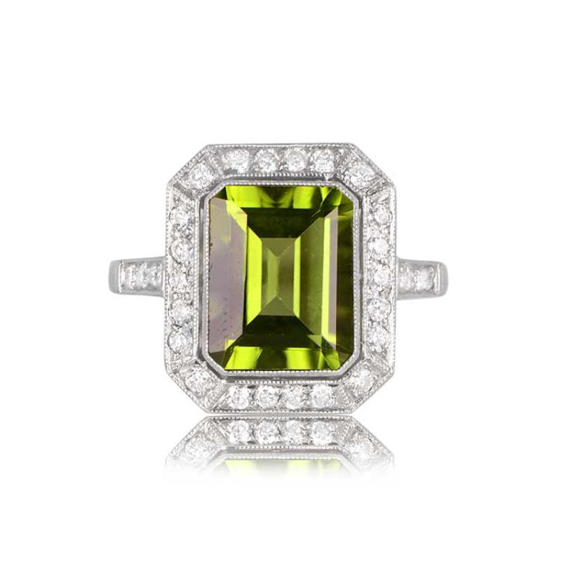 An exquisite platinum and diamond halo ring showcases a vibrant 3.16-carat natural emerald-cut peridot. The center stone is encircled by a row of sparkling round brilliant-cut diamonds. This ring boasts a sleek low-profile design.


Ring Size: 6.5