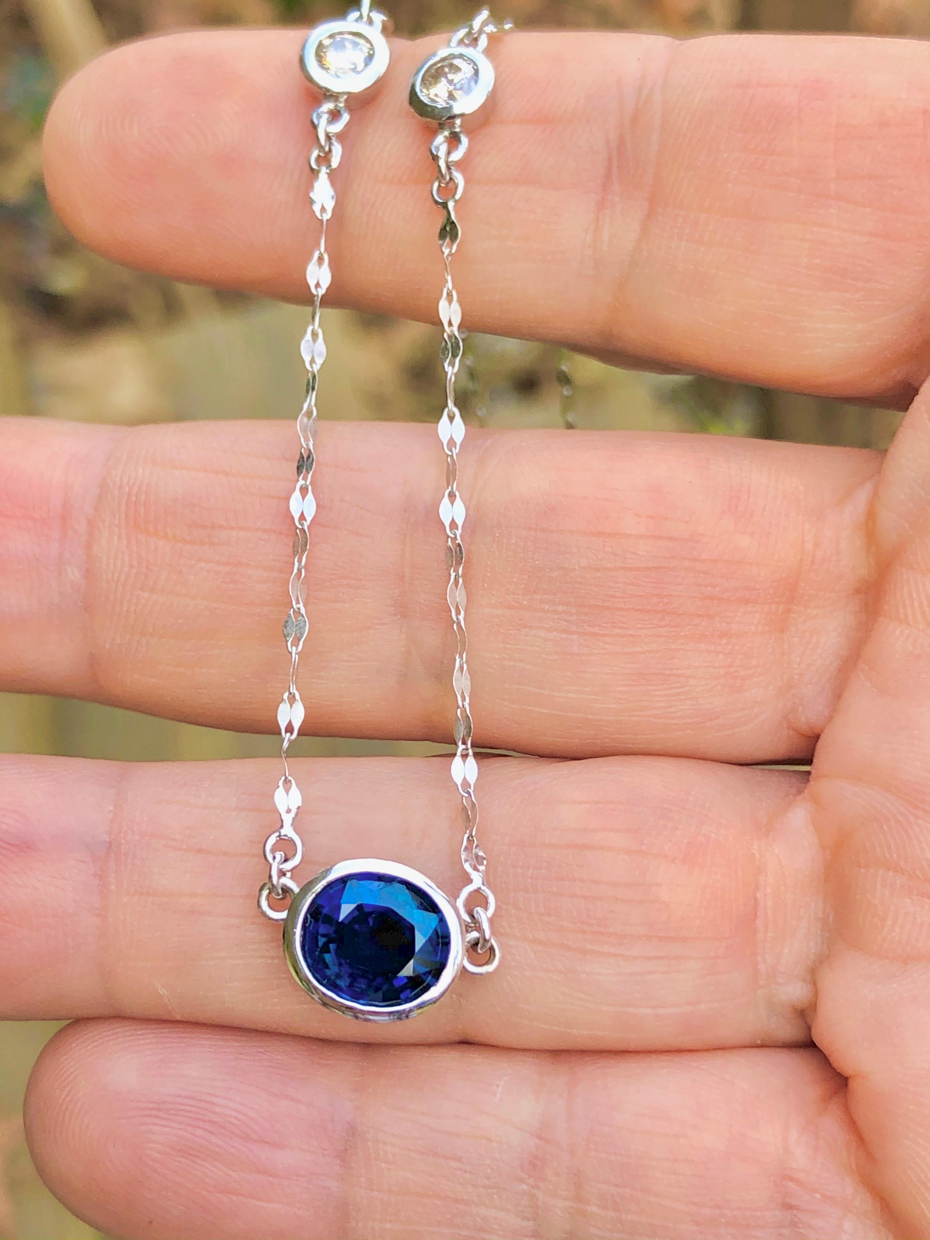 A unique solitaire pendant necklace showcasing a single oval shape natural royal blue sapphire weighing 2.85 carats, suspended on a 18 inch white gold chain accented with two round brilliant diamonds. Accent diamonds weigh 0.32 carats total. All the