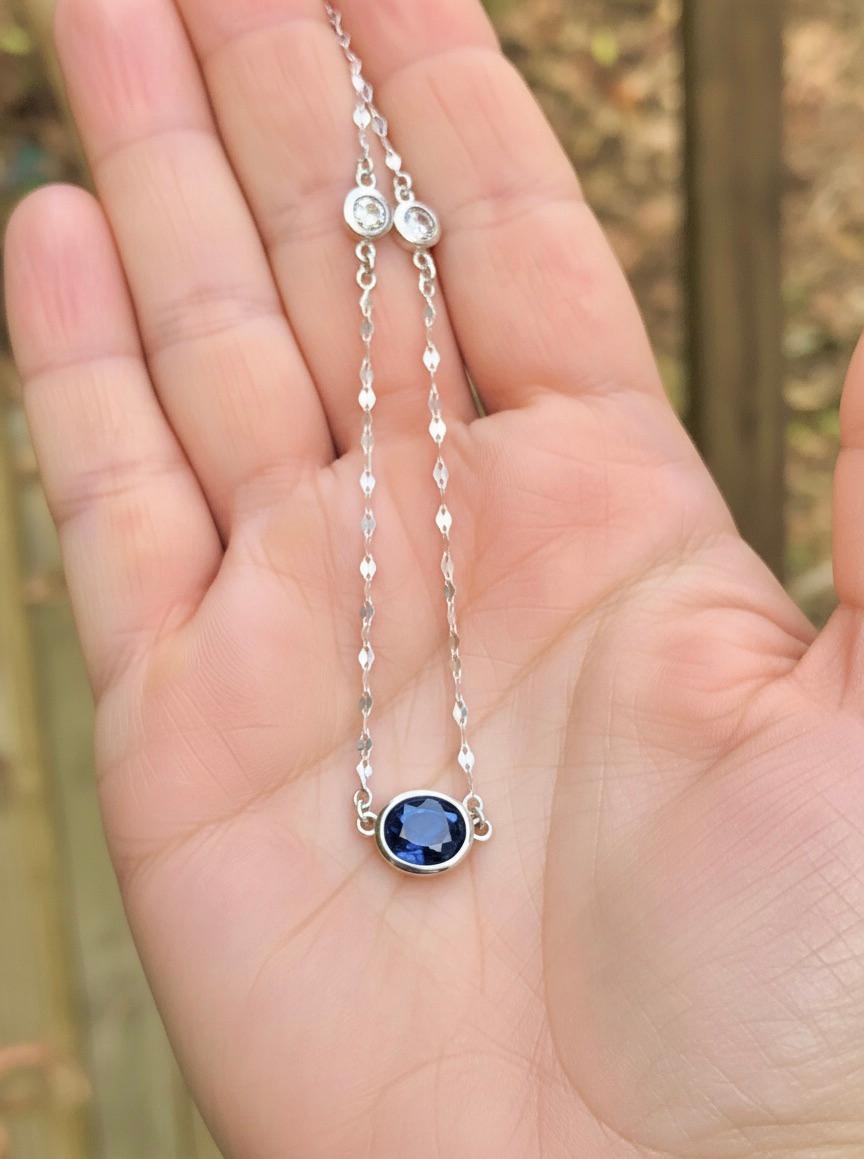 Un collier pendentif solitaire unique mettant en valeur un saphir bleu royal naturel de forme ovale pesant 2.85 carats, suspendu à une chaîne en or blanc de 18 pouces accentuée de deux diamants ronds de taille brillant. Les diamants accentués pèsent