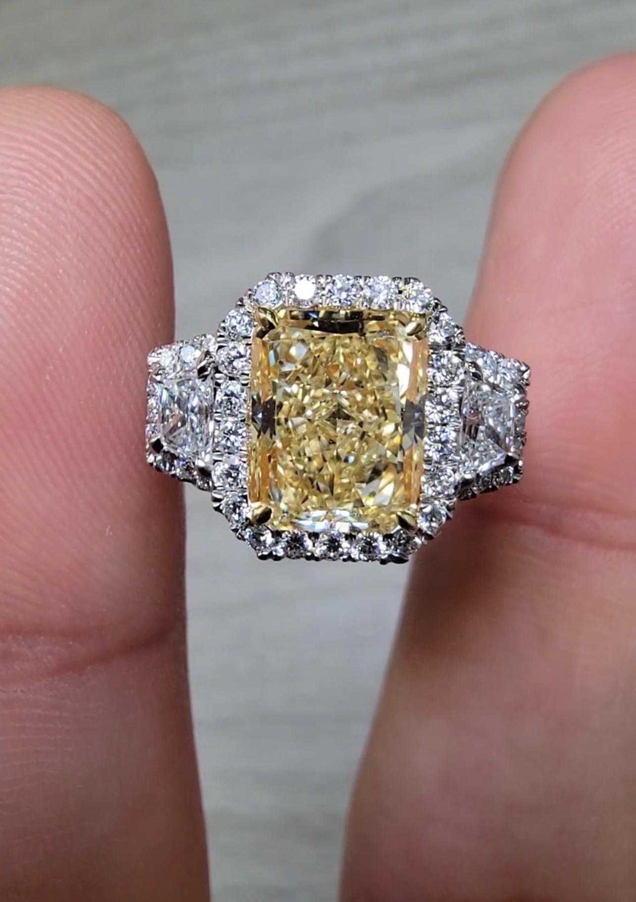 GIA U-V color rectangular radiant
Great spread and life!
Set in a Platinum and 18kt Yellow Gold Halo/Three Stone Ring with 0.37ct F VS Trapezoids and 0.87ct of round white diamonds