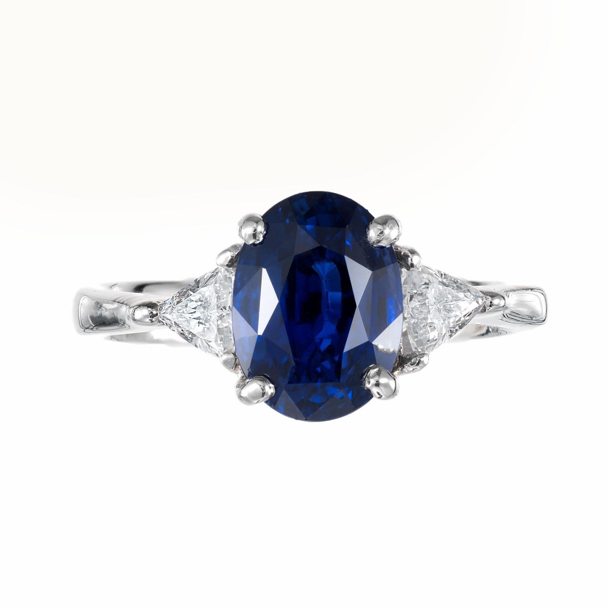 Royal blue sapphire and diamond engagement ring. GIA certified oval center sapphire accented with two trilliant cut diamonds, in a three-stone platinum setting designed and created in the Peter Suchy Workshop. 

1 oval gem Royal Blue Sapphire,