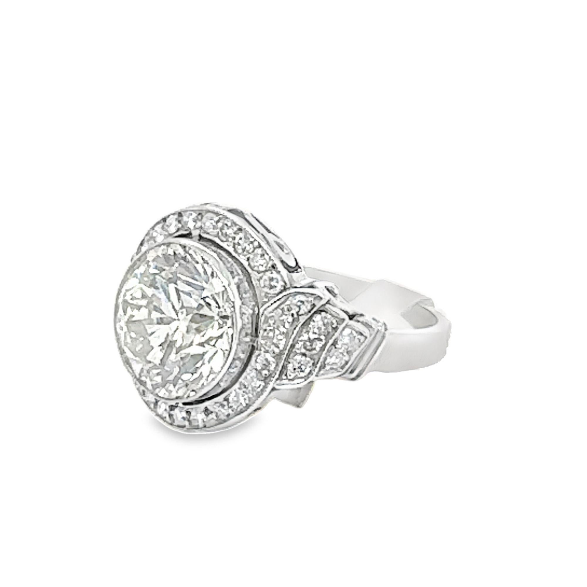 Expertly crafted with a 3.18 carat diamond in the center, this platinum ring showcases the stunning center diamond with J-K color and SI1 clarity.  Surrounding the center stone are diamonds totaling approximately 1.00 carats G-H color and VS