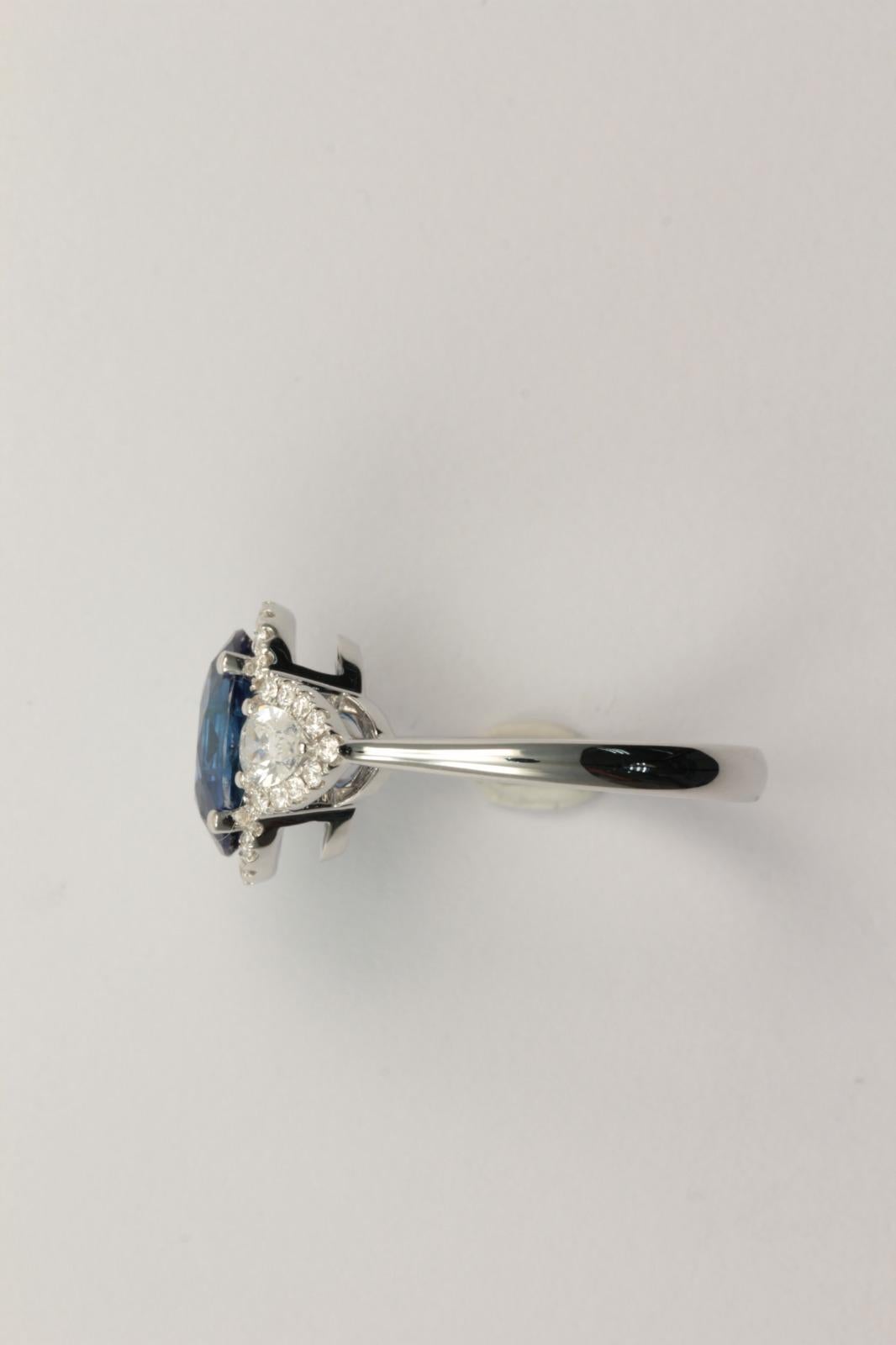 Set with an oval-shaped sapphire weighing 3.18 carats, flanked on either side by pear diamonds totaling 0.50 ct, surrounded by multiple round diamonds totaling 0.27 ct and mounted in 18k white gold, ring size 6½

Accompanied from the Gem Research