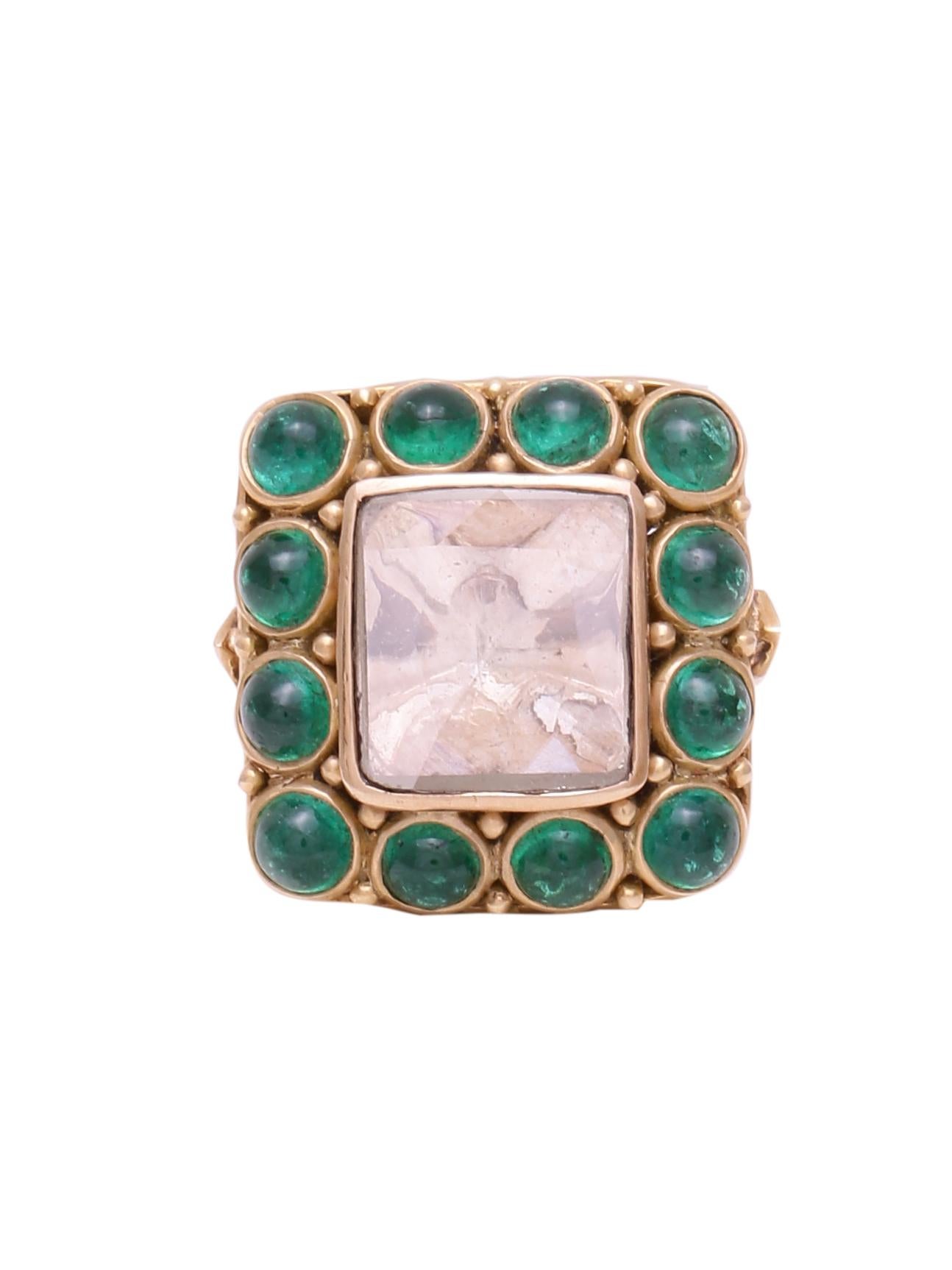 A ring with a large beautiful cushion shape diamond rose cut weighing 2.24 carats with good clarity surrounded by Emerald Round Cabochons. The whole ring is handcrafted in 18K Yellow gold. You will notice really intricate work on the back of the