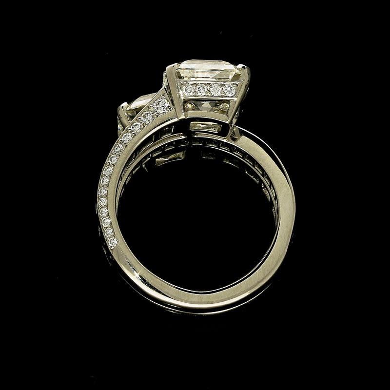 3.04ct J VS1 emerald cut diamond with GIA certificate 
3.18ct I VVS2 emerald cut diamond with GIA certificate 
3cts of calibre cut sapphires
0.65cts of round brilliant diamonds
Platinum with maker's marks and London assay marks
UK finger size L, can