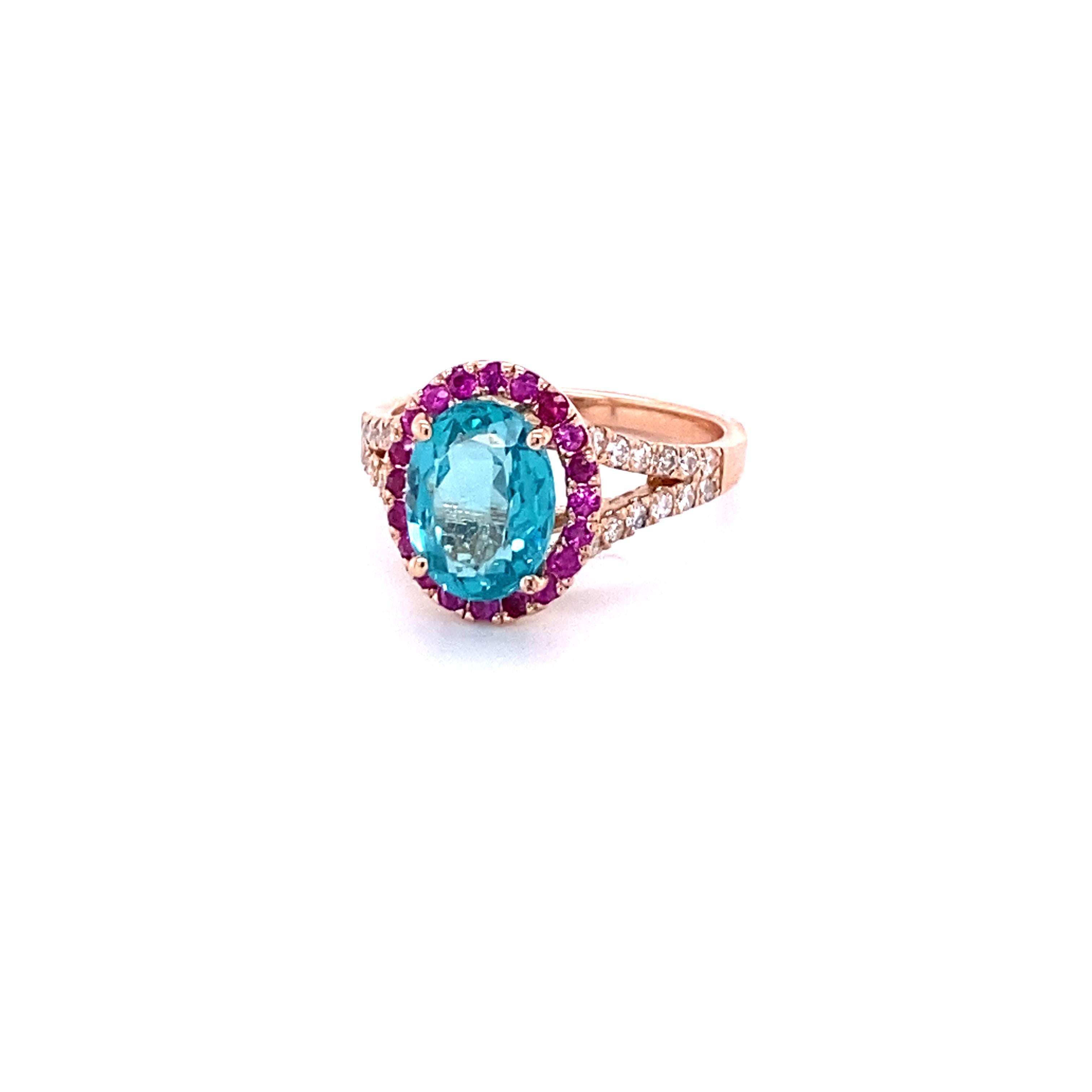 This ring has a 2.60 Carat Oval Cut Apatite in the center of the ring and is surrounded by 20 Pink Sapphires that weigh a total of 0.31 carats and 24 Round Cut Diamonds that weigh 0.28 Carats. The Clarity and Color of the Diamonds is SI-F. The total