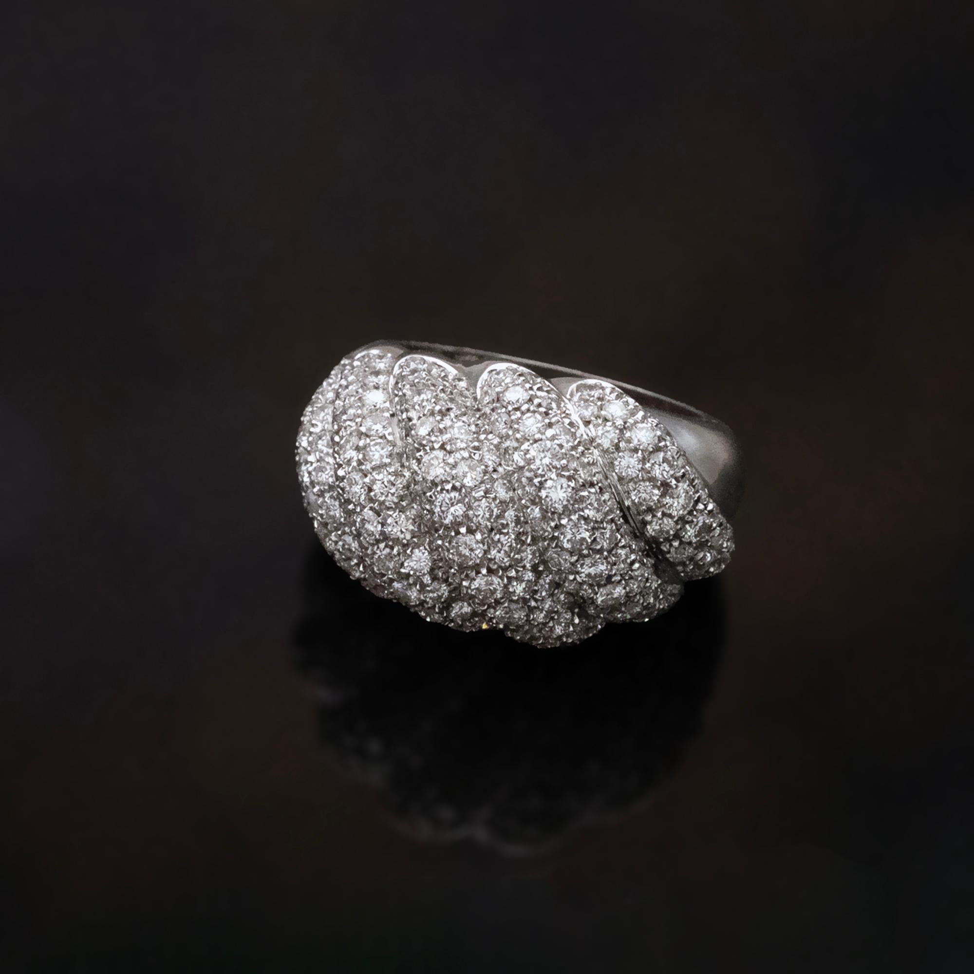 This bold 18K white gold dome ring features a sculptural design with godron-style ridges, each pavé-set with 3.19 carats of high-quality FG color, VS+ clarity diamonds. The curved, overlapping segments create a dimensional surface that reflects