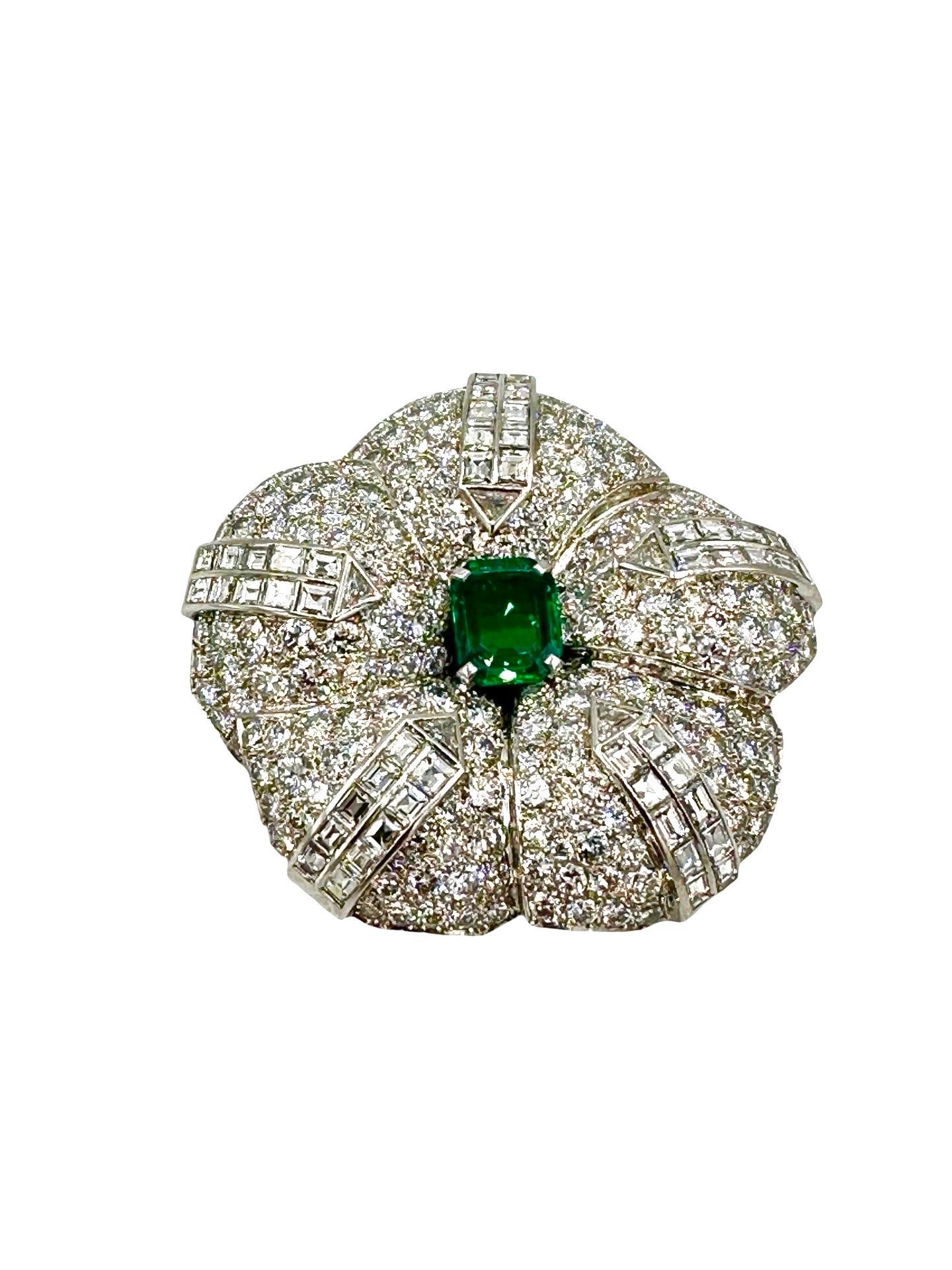This brooch is amazingly gorgeous!  This makes any wardrobe better at any occasion.  The brooch features a stunning green emerald cut Emerald in the center, weighing 3.19 carats.  There are a mix triangular cut, ascher cut, and round brilliant cut