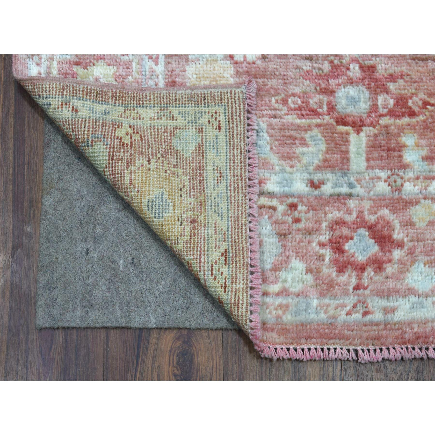 Il s'agit d'une véritable pièce unique, nouée à la main en Angora Oushak rose corail avec des motifs colorés, en laine organique, tapis de course oriental XL. Il a été noué pendant des mois et des mois selon des techniques de tissage séculaires par
