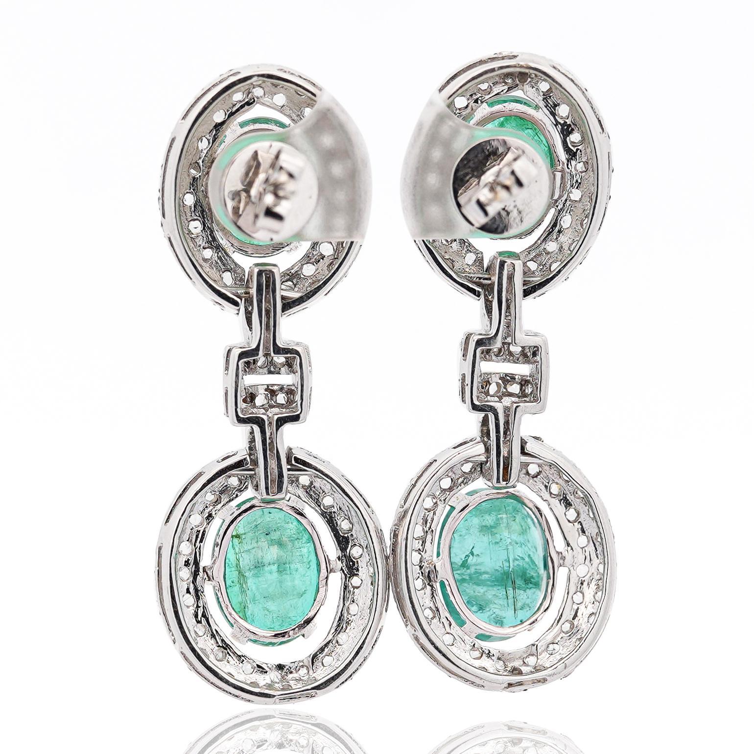An extraordinary 18K white gold statement jewelry set, featuring a statement necklace and matching earrings, adorned with 32 carats of unmistakably natural emeralds. The bold, rose-cut diamonds complement the green emeralds with excellent luster,