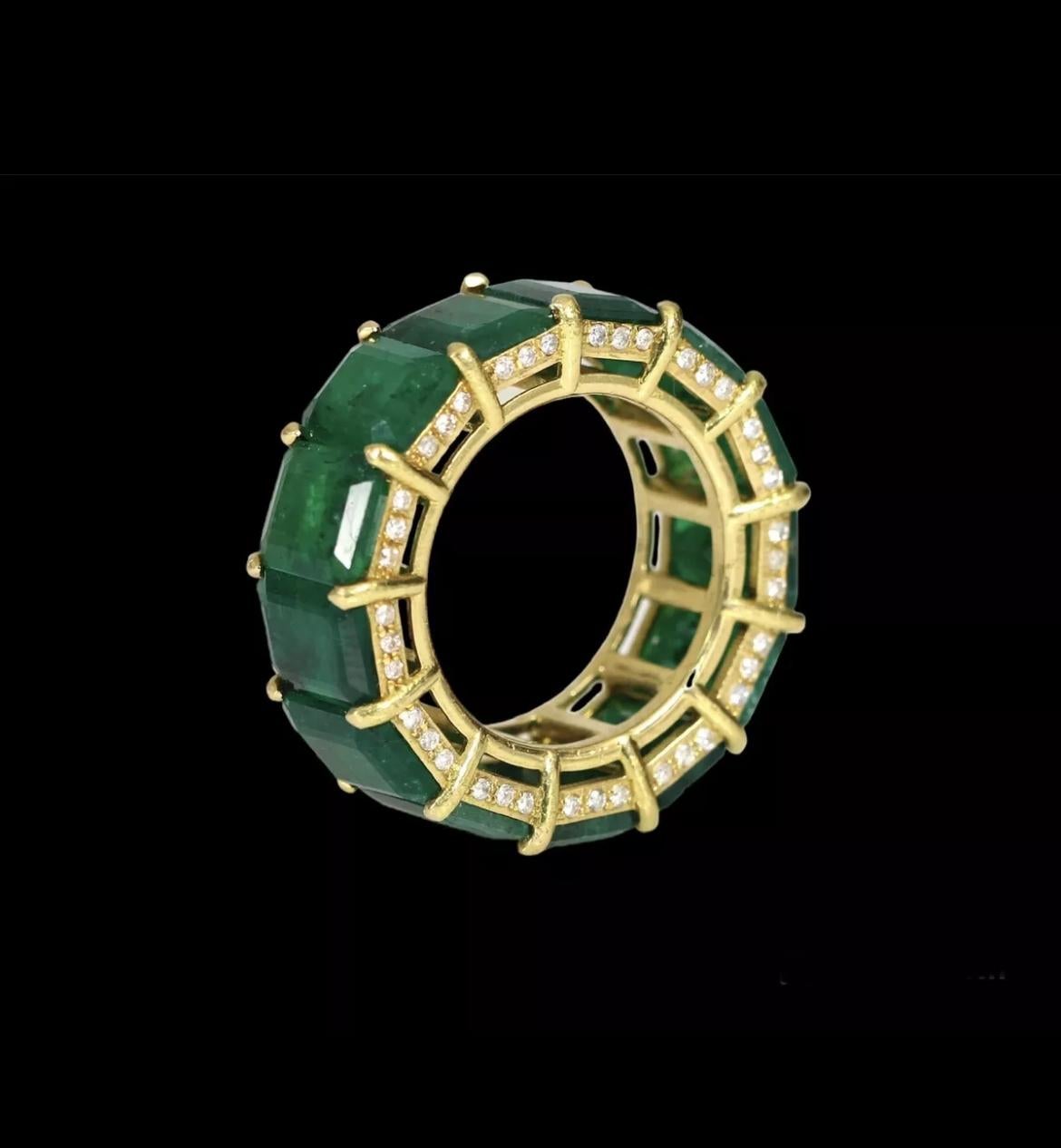 Up for sale is this stunning 18k yellow gold eternity band ring featuring a breathtaking 32.00 total carat weight of natural emeralds and a 1 carat weight diamond detail. The beautiful green emeralds are prong-set in a nature-inspired eternity band,