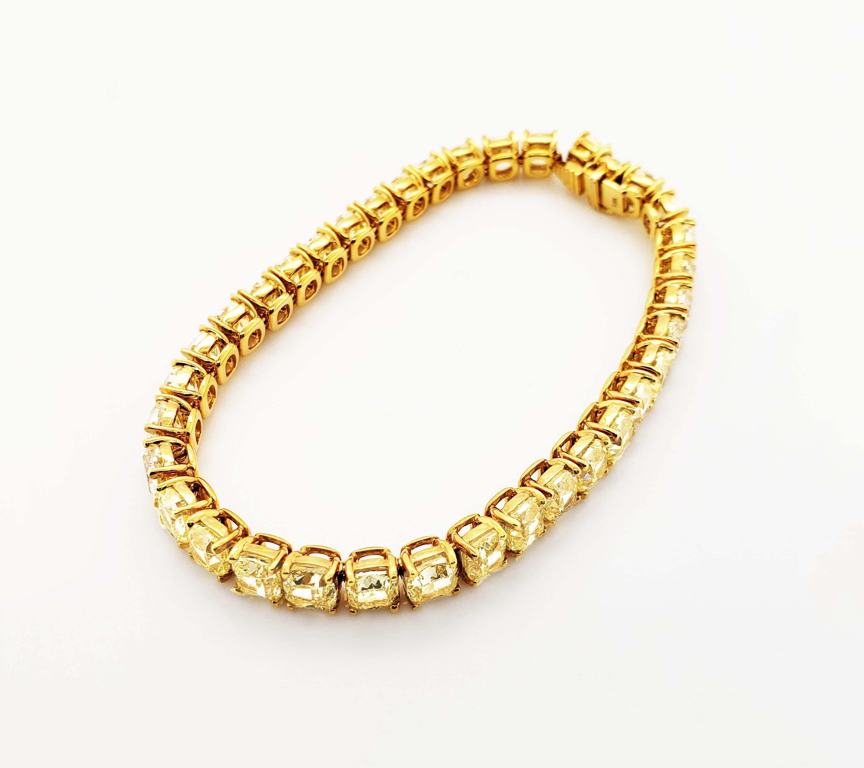 Natural fancy-yellow diamond line bracelet containing 32.78 carats of matched fancy yellow cushion cut diamonds of clarity grades VS2 to IF - each diamond is GIA graded with a report. GIA-certified diamond tennis bracelet with fancy yellow
