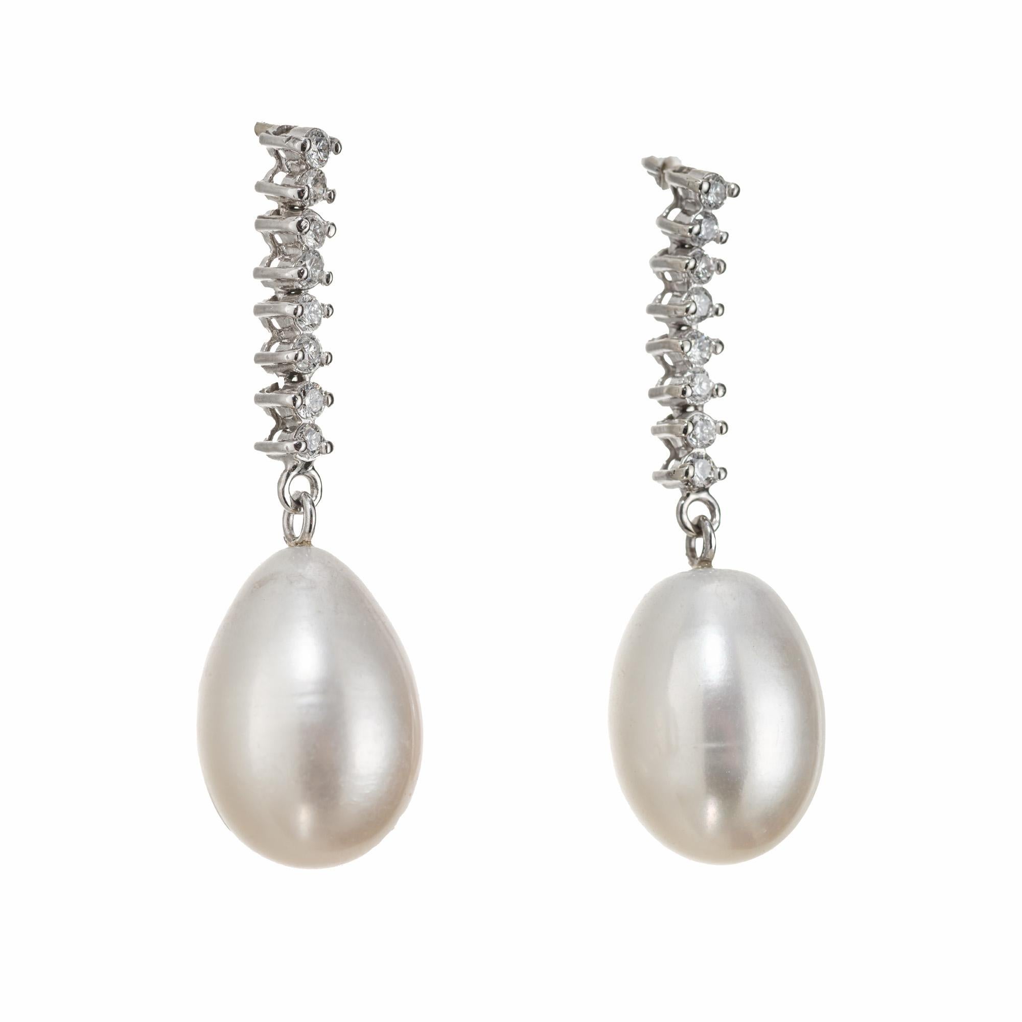 Tear drop freshwater cultured pearl and diamond dangle drop earrings. Wedding style, Two pear shaped, 10.5mm-14.7mm Pearls accented with 8 round cut diamonds in 14k white gold.

16 round diamonds, H-I SI approx. .32cts
2 freshwater white pearl