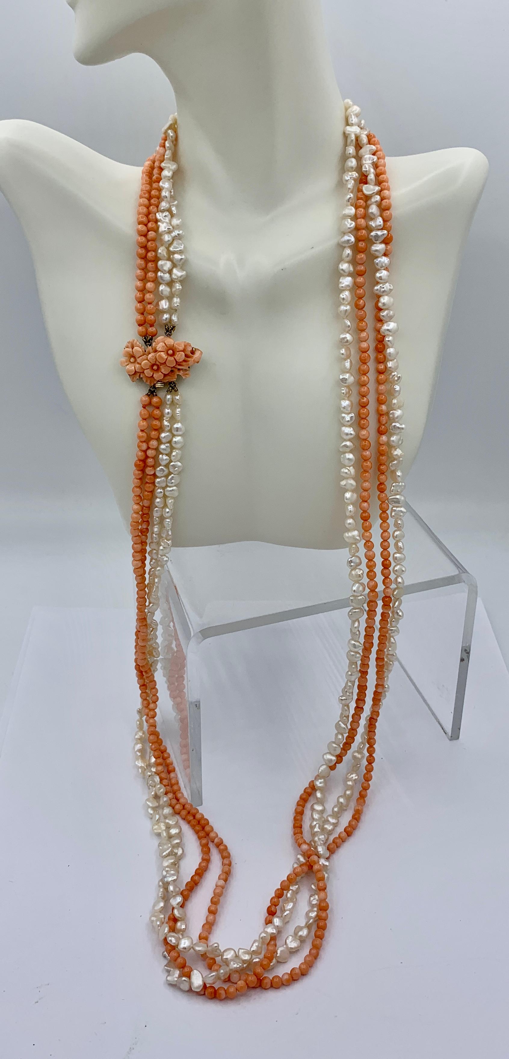 This is a stunning antique salmon colored Coral and Pearl four strand torsade necklace with a beautiful hand carved Coral clasp with a design of a flower, branch and leaves.  The coral clasp is 14 Karat Yellow Gold.   The clasp is a beautiful