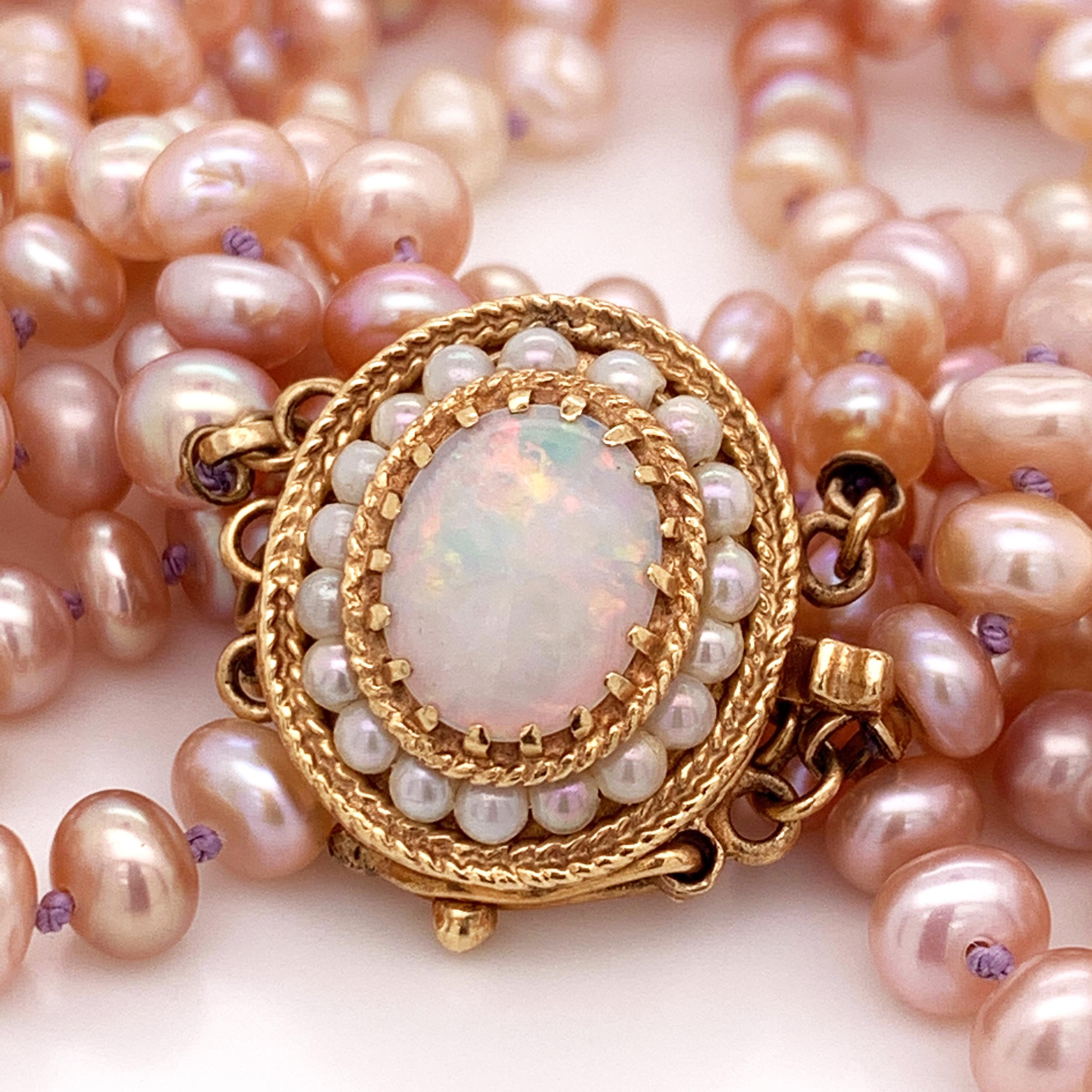 This absolutely stunning natural pink freshwater pearl double strand necklace is one of a kind and stands out even more because of the beautiful opal and white pearl adorned box and tongue clasp. This gorgeous necklace is a RARE design by 