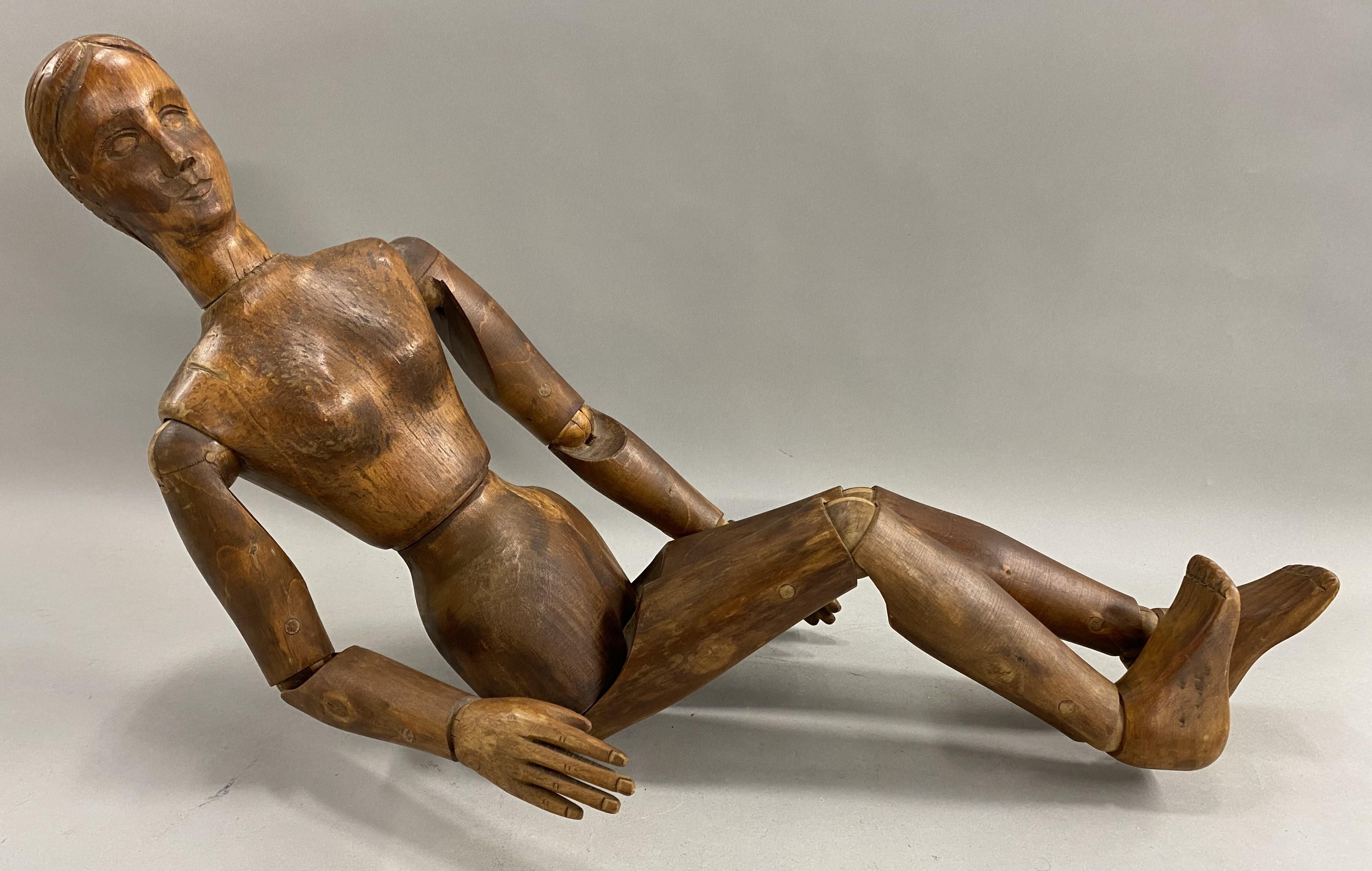 Maravilloso y raro maniquí articulado de madera con cara y pelo raramente tallados, con detalle de uñas, con articulaciones móviles en la cabeza, cintura, rodillas, codos, muñecas, tobillos, hombros y caderas. El maniquí es probablemente de finales