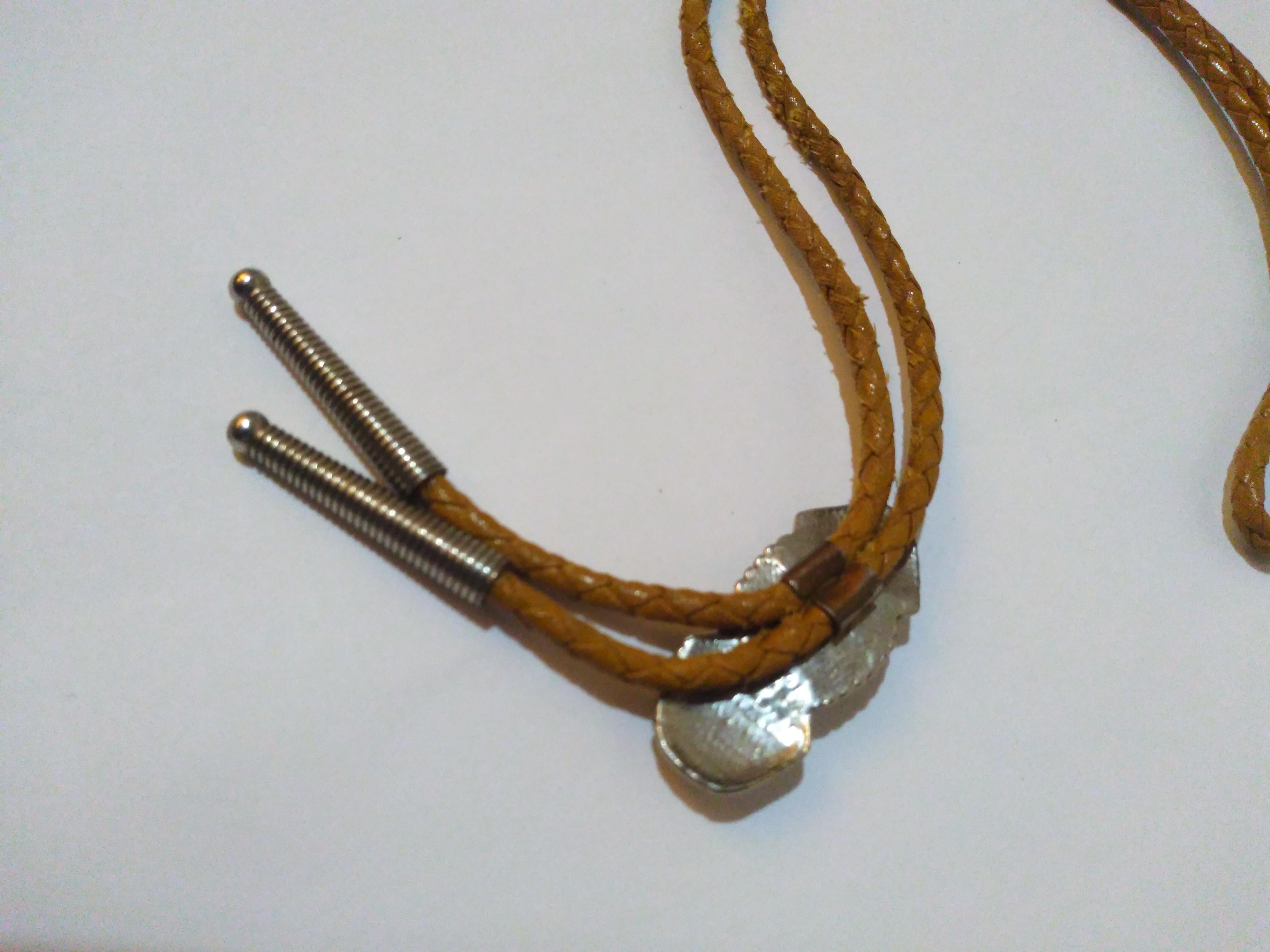 This is a beautiful bolo tie. It's made of braided leather with a sterling silver medallion with a turquoise setting. The tips are crafted in silver also.

Great for a night out on the town.


Ready to wear.