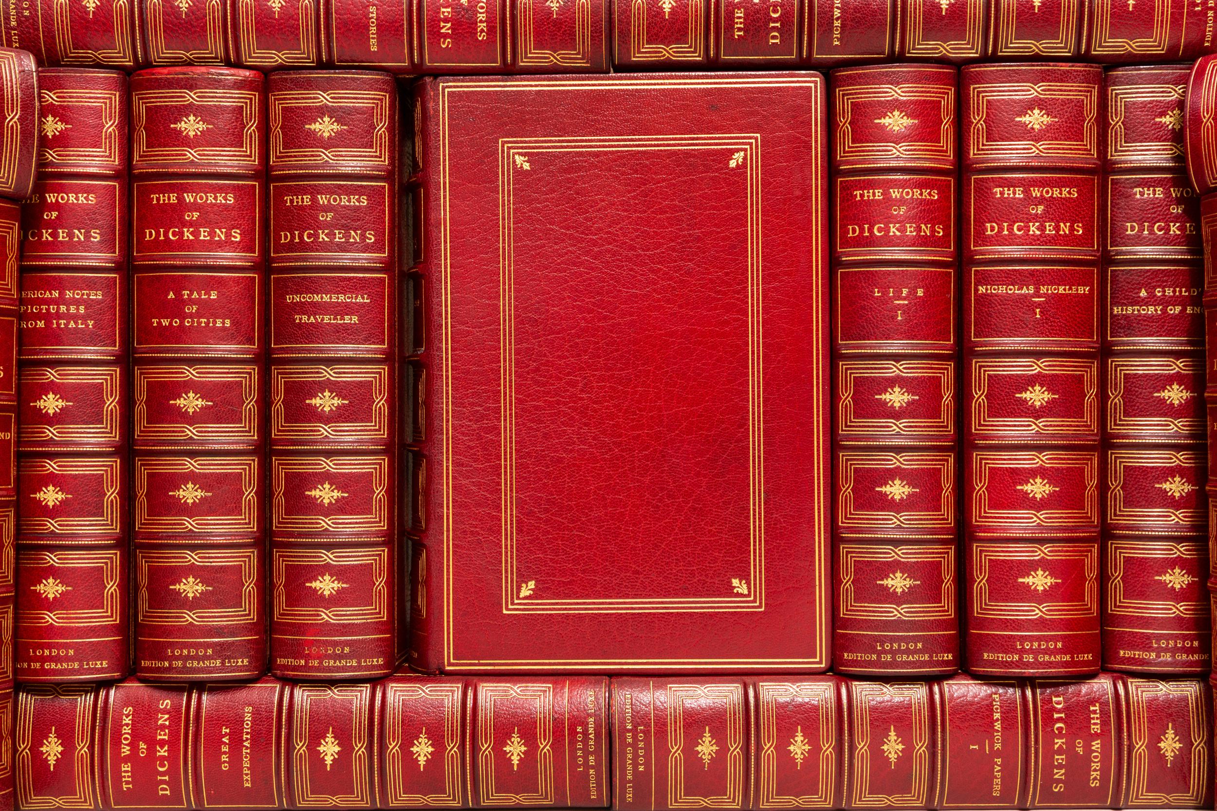 32 Volumes. Charles Dickens, The Works of Charles Dickens. Bound in full red morocco. Gilt-tooling on covers. Raised bands. All edges gilt. Decorative gilt emblems on spine. Marbled endpapers. Bound by Macdonald's Bindery. Limited to 500 numbered