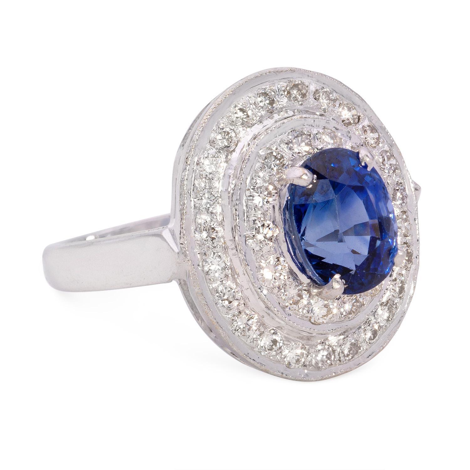 Experience timeless elegance with our 3.20 Carat Blue Sapphire Diamond Cluster Ring. This luxurious piece features a striking 3.20 carat oval Blue Sapphire, renowned for its deep, mesmerizing blue hue and fine clarity. The sapphire, positioned as