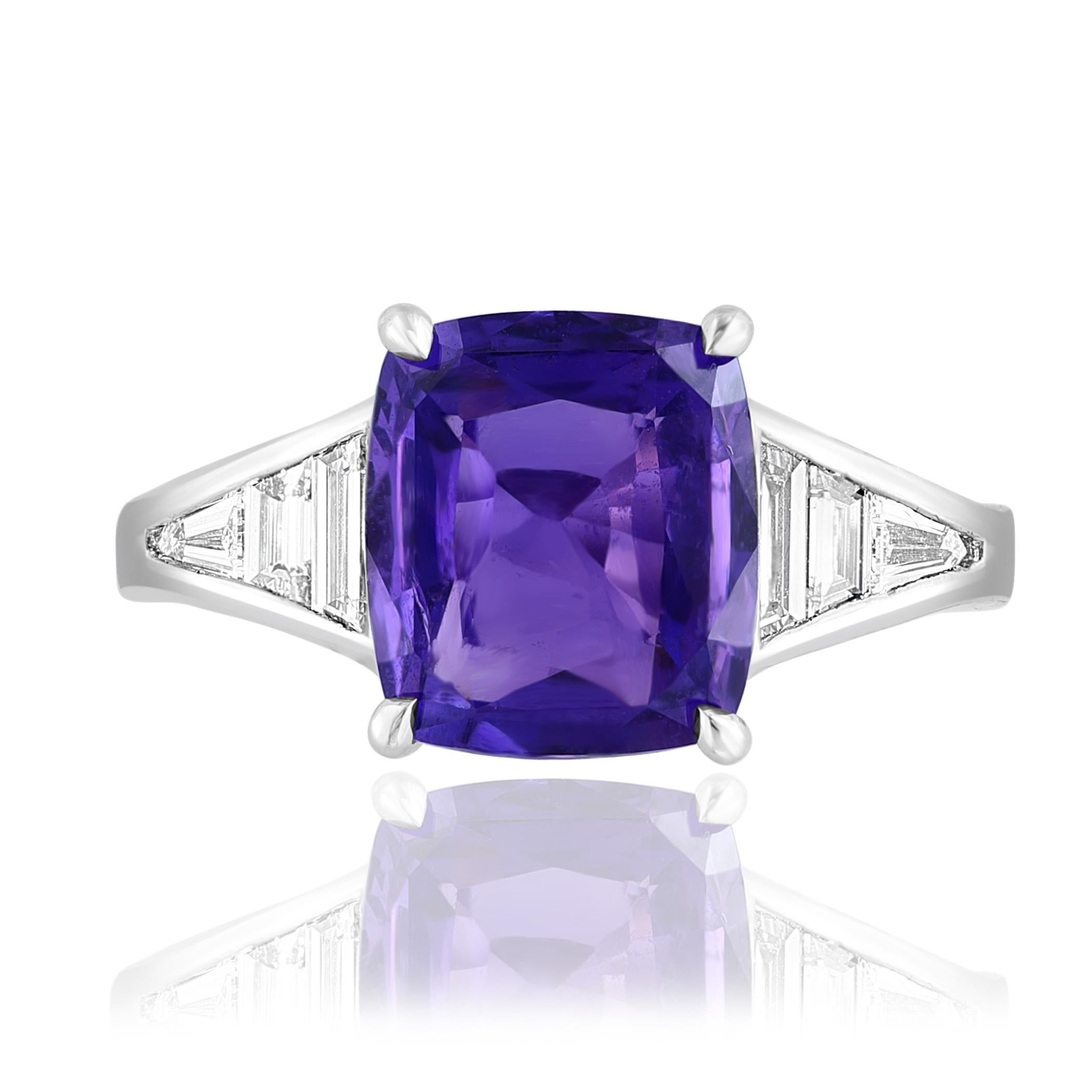 A stunning well-crafted engagement ring showcasing a 3.20-carat Cushion Cut Purple Sapphire. Flanking the center diamond are perfectly matched graduating step-cut diamonds, channel set in a polished platinum mounting. 6 Accent diamonds weigh 0.58