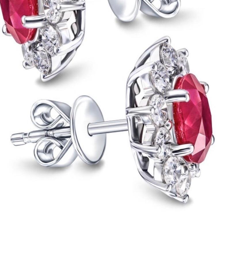 Elegant and striking 3.20 Carat total diamond and ruby Cluster earrings, The radiant oval ruby in the centre on each earring is surrounded by 10 white stunning diamonds, 20 diamonds for both, weighing a total of 1.20 carat color G/H clarity SI, the