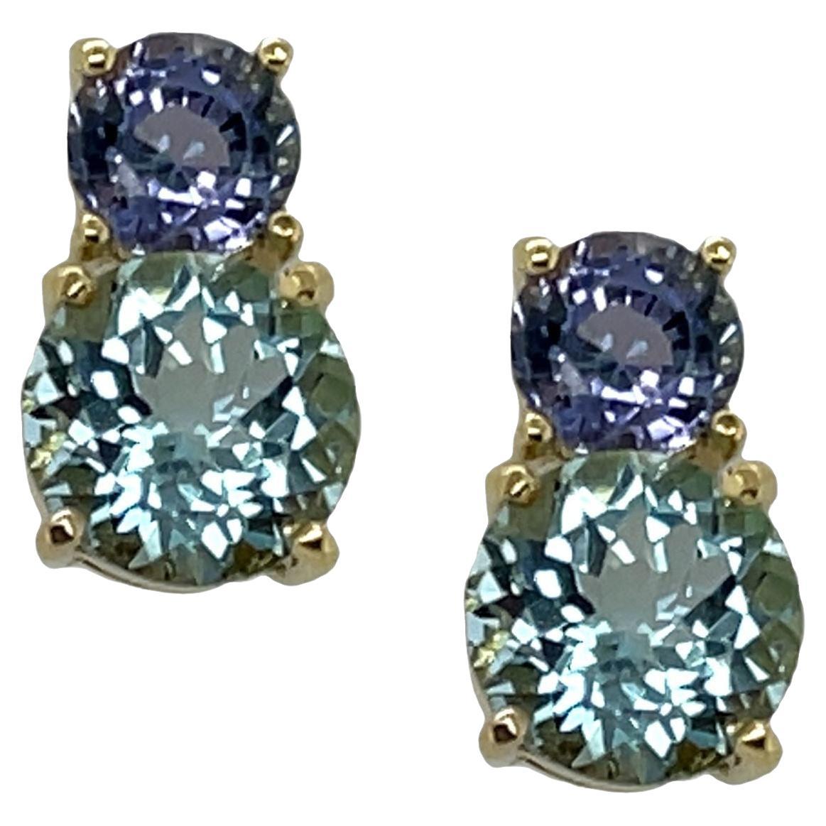 Cool, sparkling gems in warm 18k yellow gold - this beautiful combination of colors is designed to please the eye and delight the senses! Sparkling blue aquamarines weighing over a carat and a half each are paired with brilliant lavender tanzanites