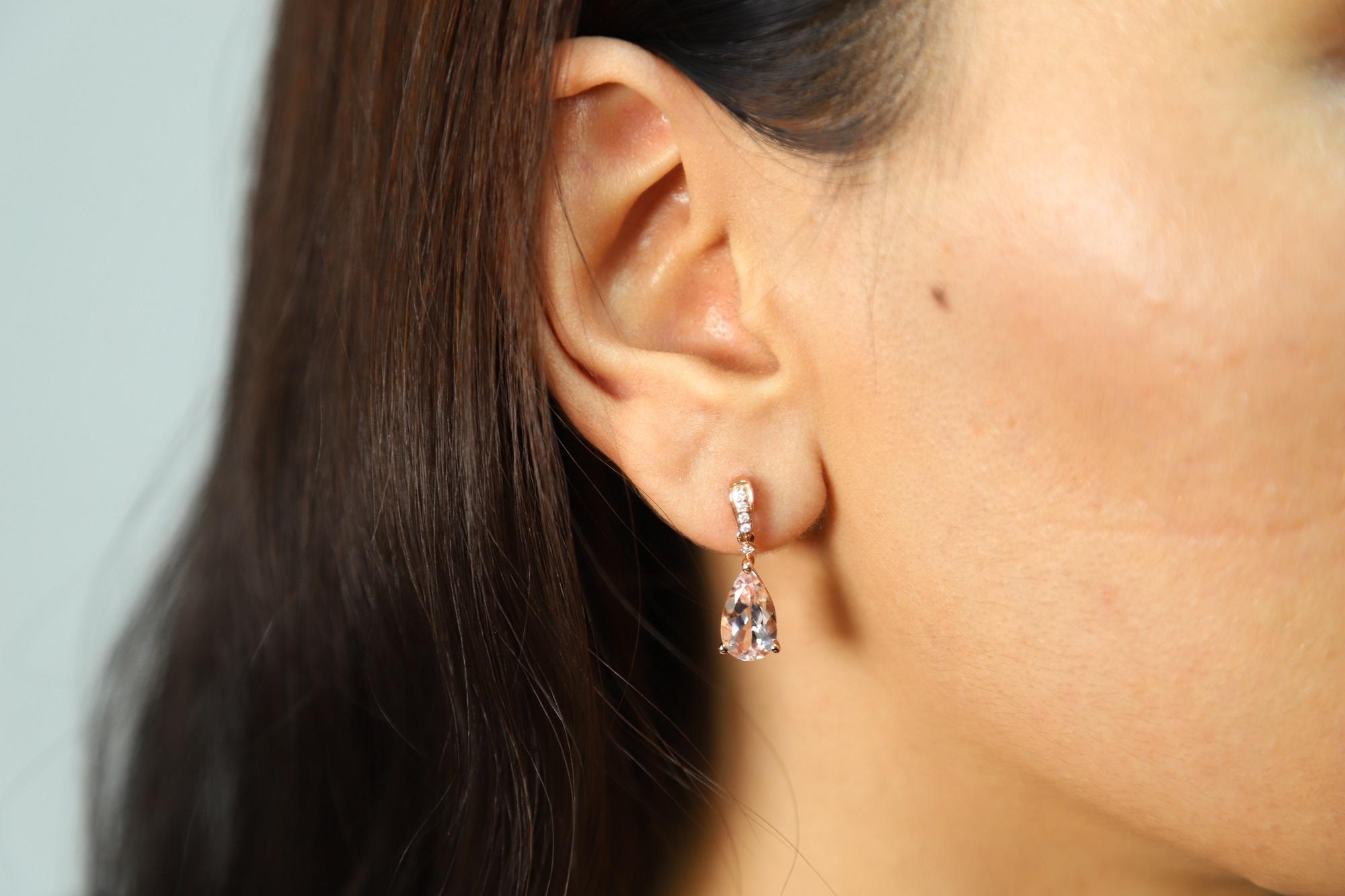 These remarkable dangle earrings showcase beautiful pear-cut Morganite gemstones with a perfectly complementing 14-karat rose gold frame that offers a warm design. Worn with comfortable butterfly clasps with a dazzling row of Gin & Grace Natural