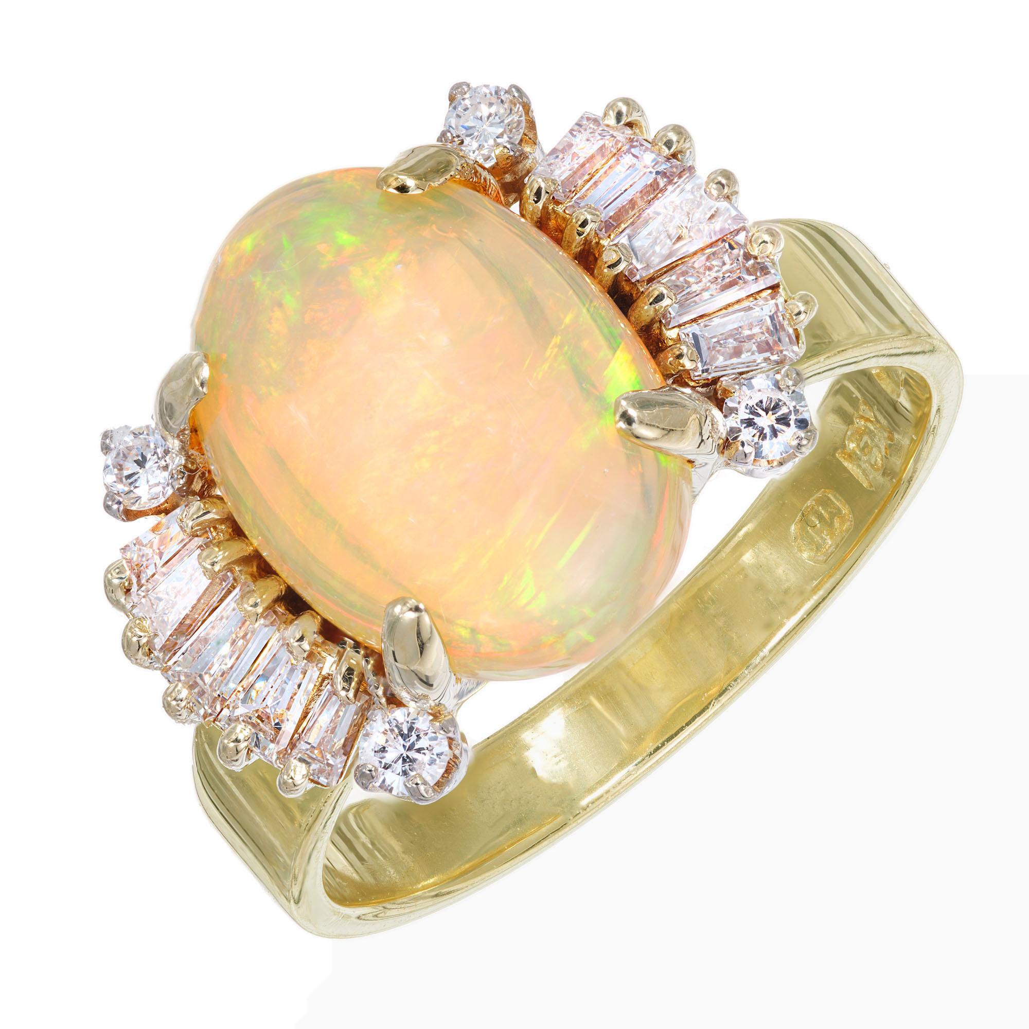 1960's Oval opal and diamond ring. 3.20 carat oval cabochon center opal with 4 round and 10 tapered baguette cut diamonds in a 18k yellow gold setting. The opal consists of  Red and orange flashes with green and blue overtones. Handmade wire setting