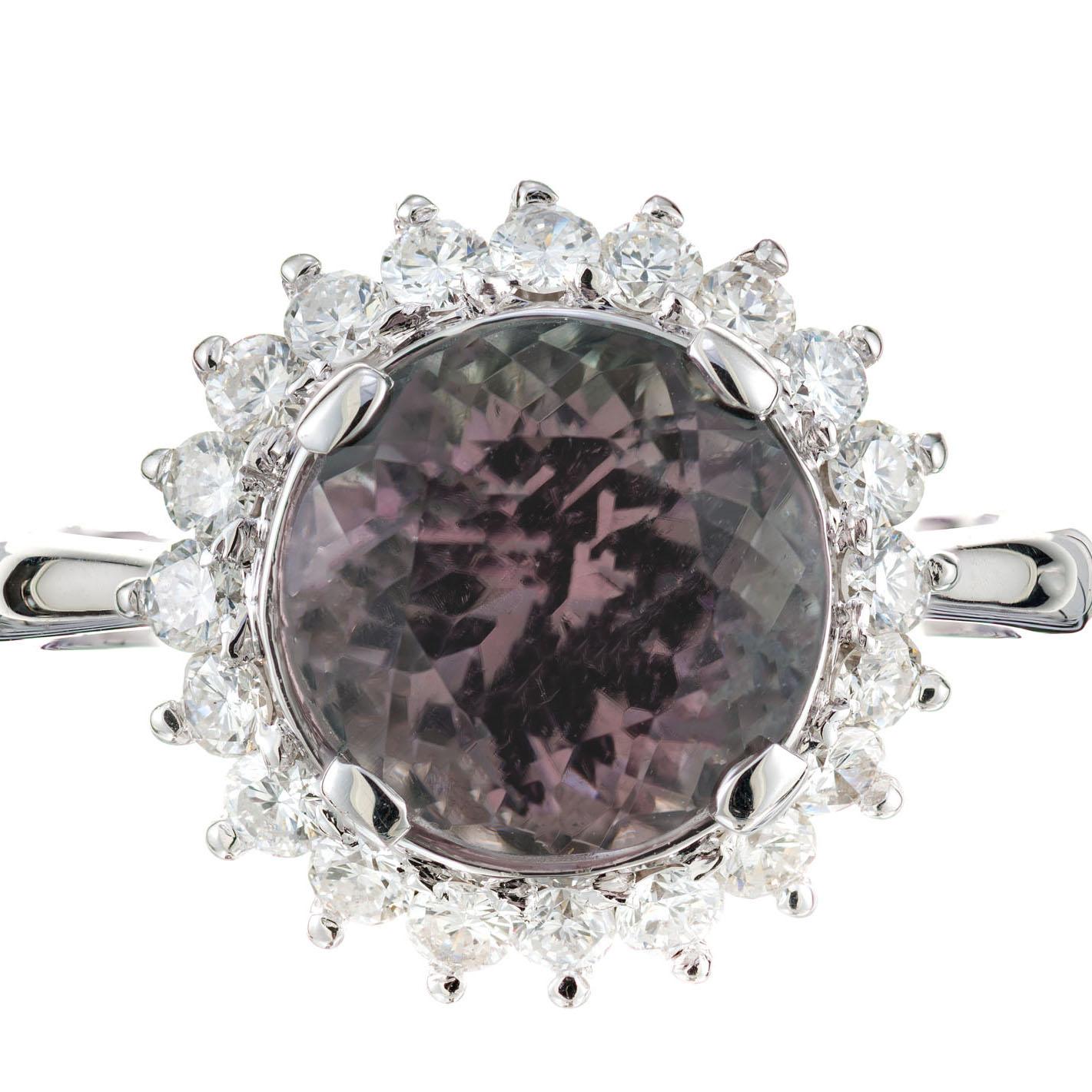 1960's Tourmaline and diamond engagement ring. 3.20ct tourmaline center stone with a halo of round diamonds in a platinum setting. The tourmaline is bi-color pink and purple, natural untreated.

1 round pink purple tourmaline, SI approx. 3.20cts
20