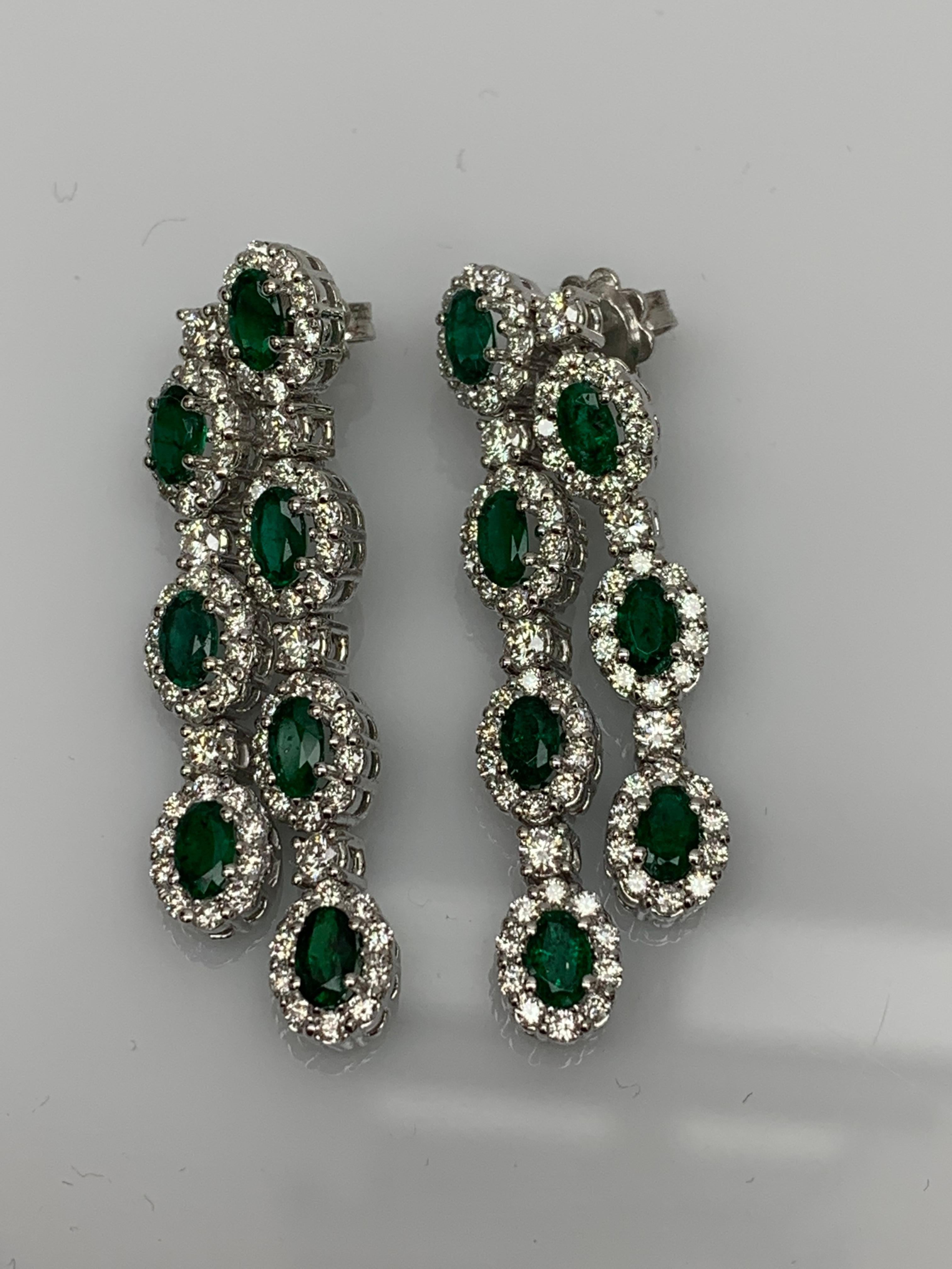 Ces extravagantes boucles d'oreilles pendantes présentent deux rangées de 14 émeraudes de taille ovale pesant 3,20 carats au total, chacune étant sertie dans un halo de diamants brillants. Les diamants pèsent 2,53 carats au total. Il est réalisé en